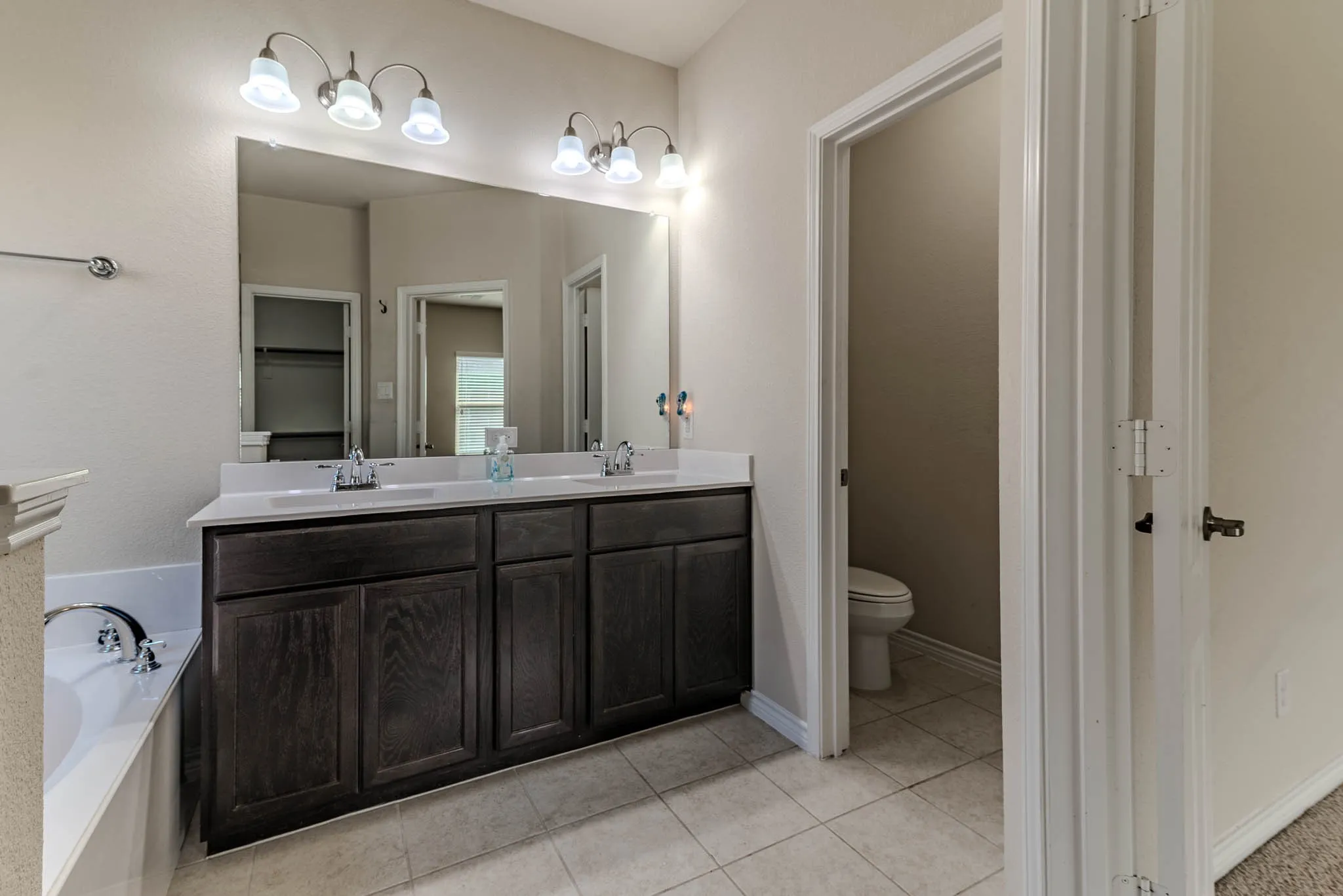 Bathroom with independent shower and bath, vanity, dual sinks and tile patterned floors