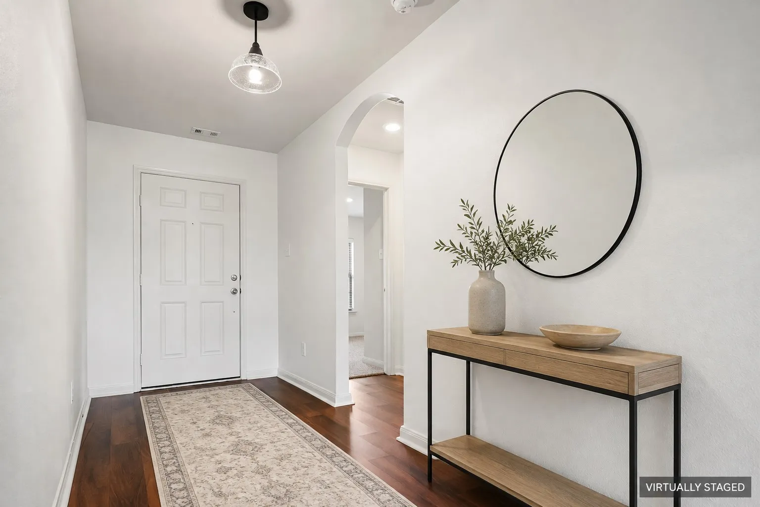 Virtually Staged Foyer. Entryway featuring wood-finish LVP  flooring, white walls, and an arched doorway.