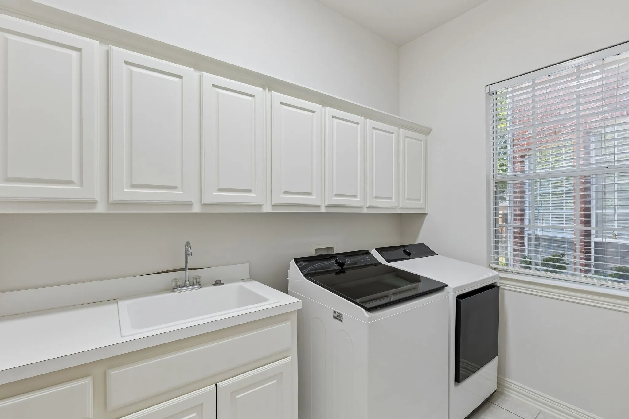 The laundry room has plenty of storage, a sink and extra room for a refrigerator too!