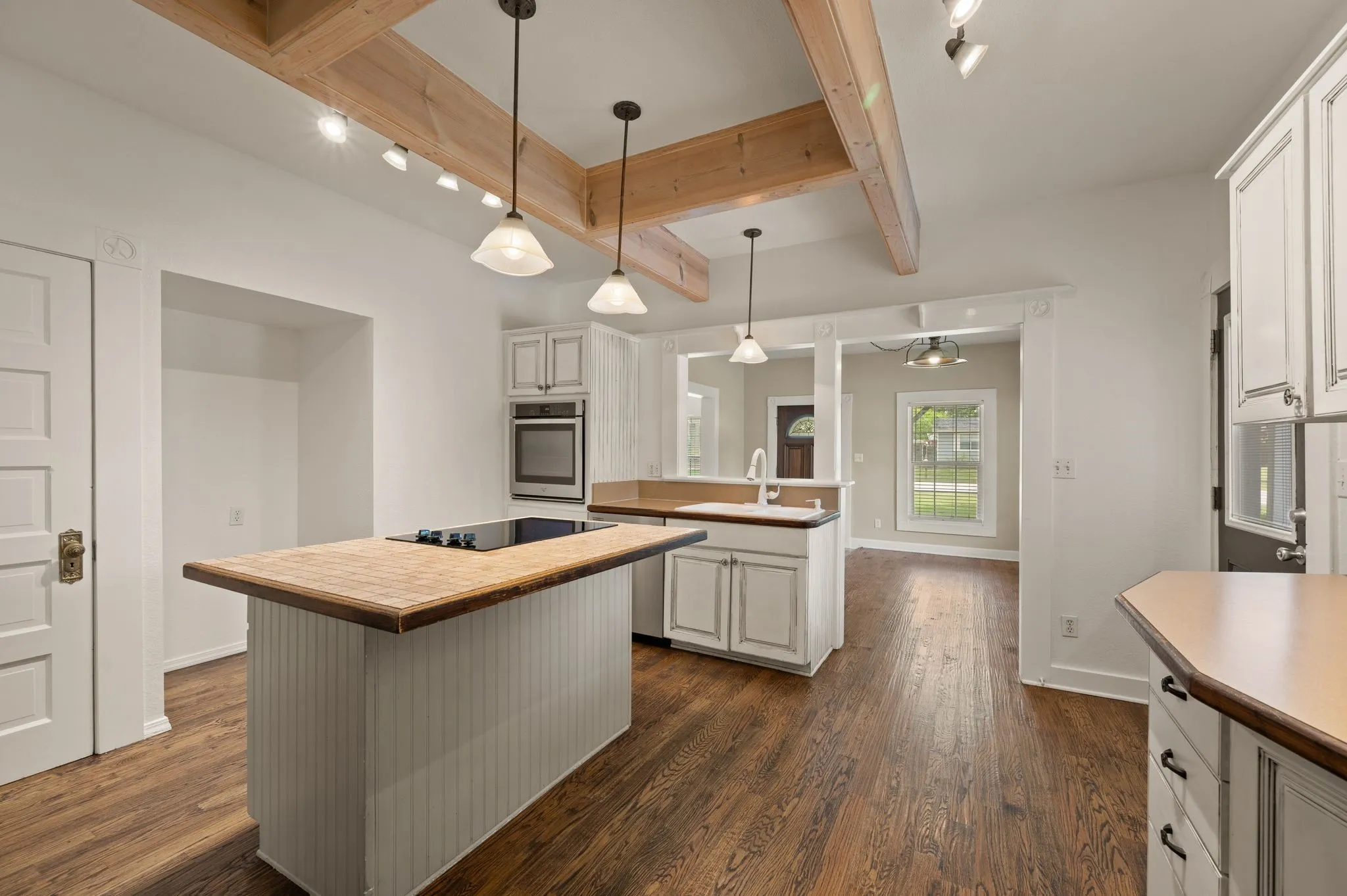 Kitchen featuring stainless steel oven, a center island, baseboards, and a sink