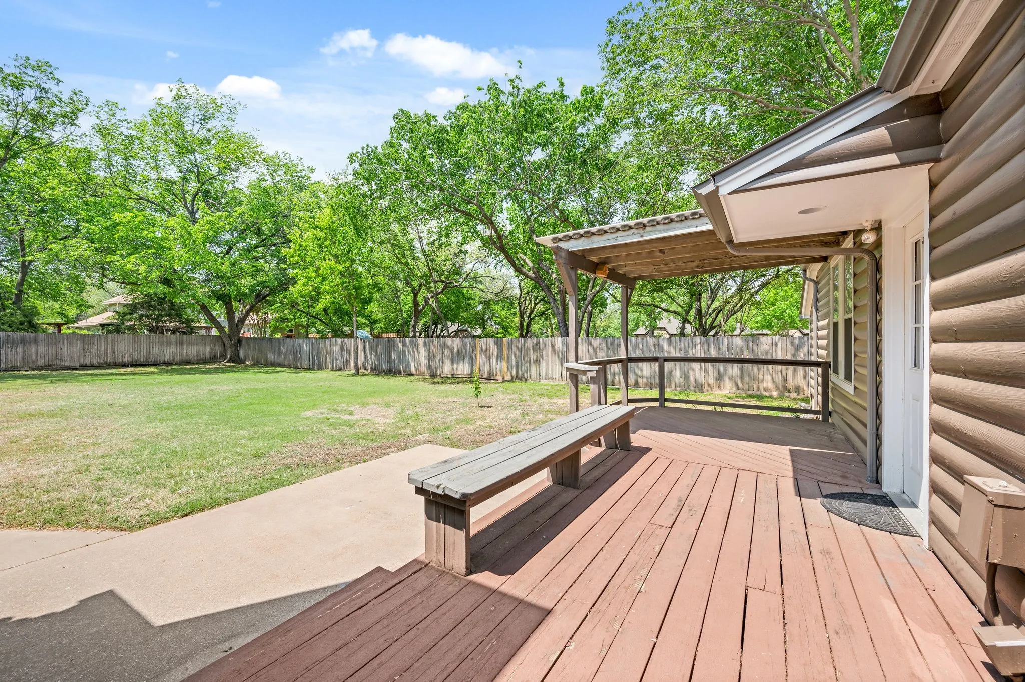 Wooden deck featuring a fenced backyard, a yard, and a patio