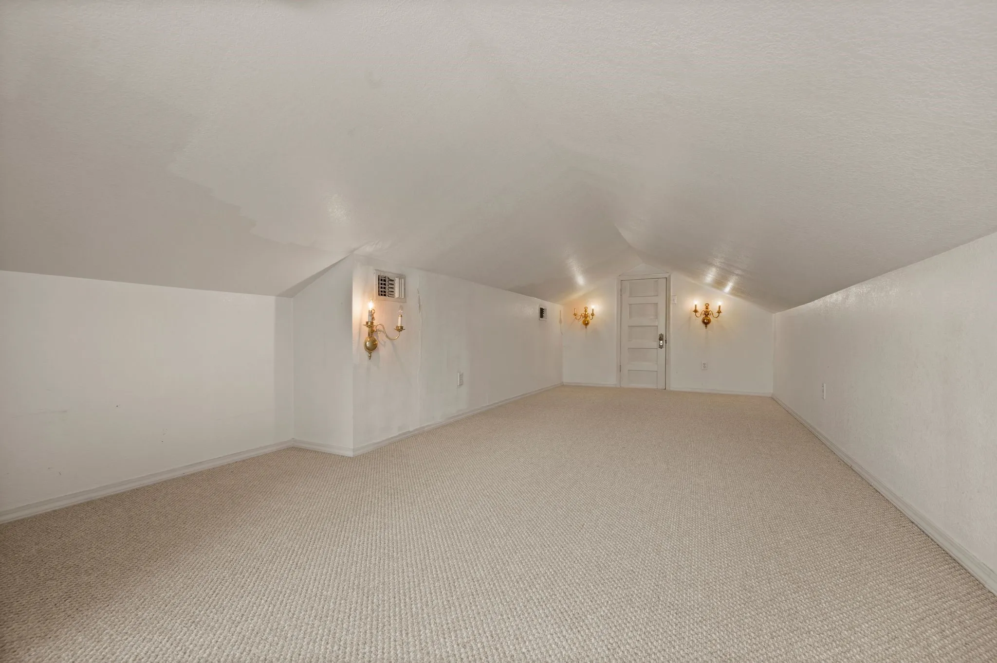 Bonus room with lofted ceiling, light carpet, baseboards, and visible vents