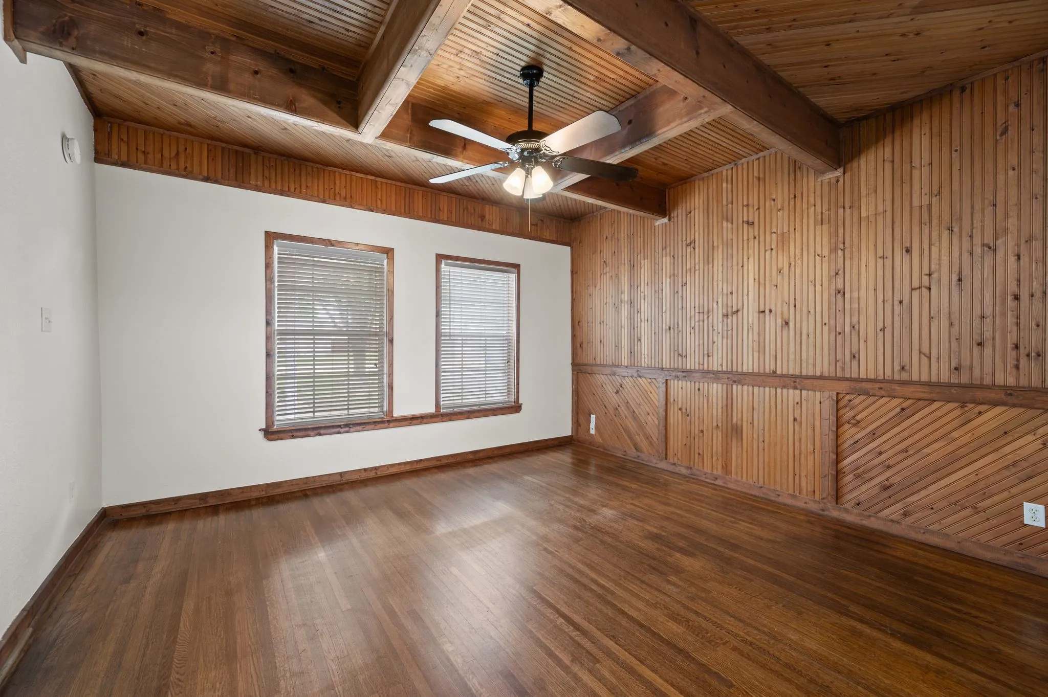 Empty room with wood ceiling, baseboards, a ceiling fan, and wood finished floors