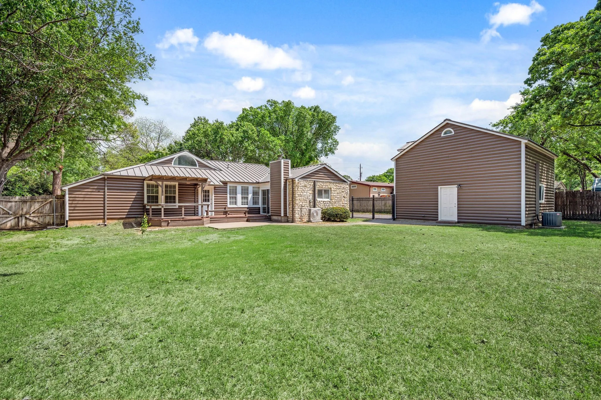 Rear view of house with a fenced backyard, cooling unit, a chimney, a patio area, and a lawn