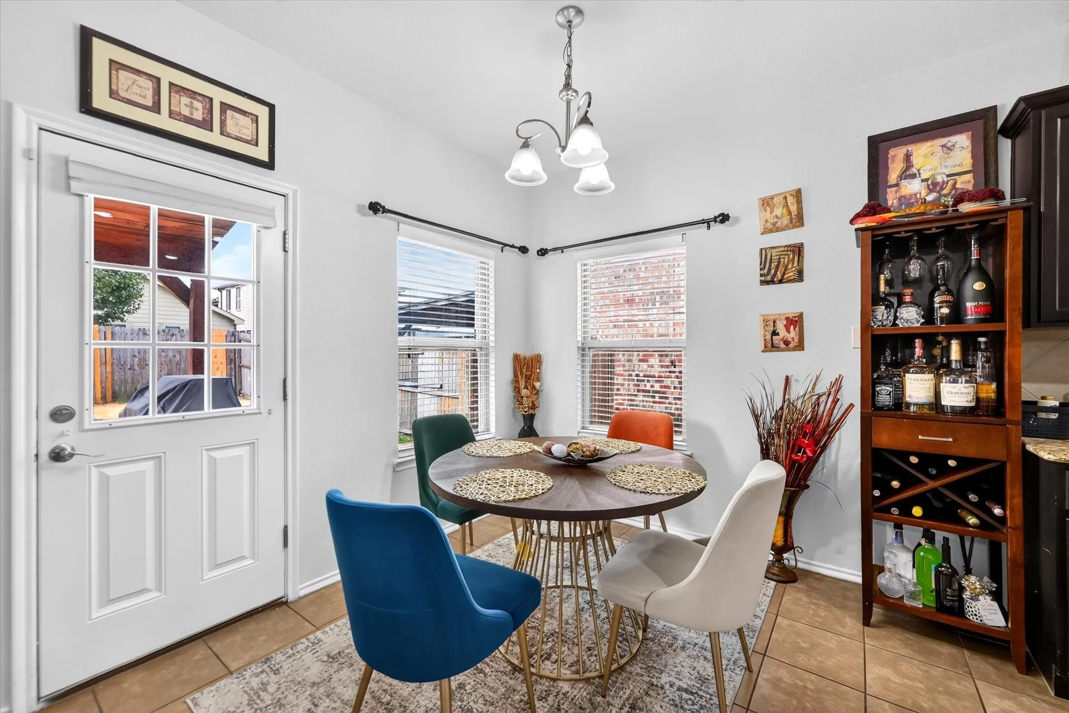 Dining area featuring tile flooring, a multi-pane door, and two windows with blinds