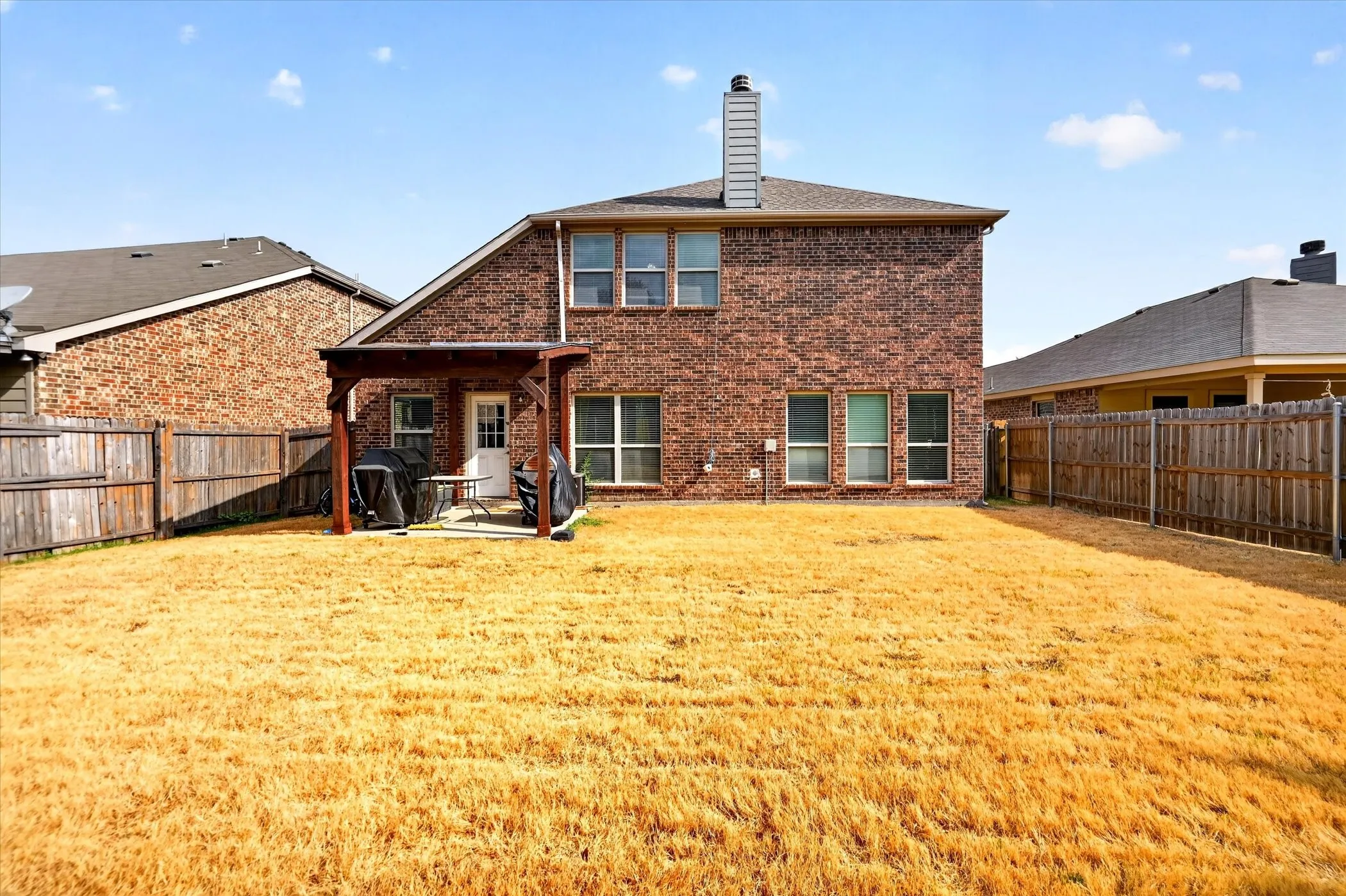 Brick exterior featuring multiple windows and a rear entry door