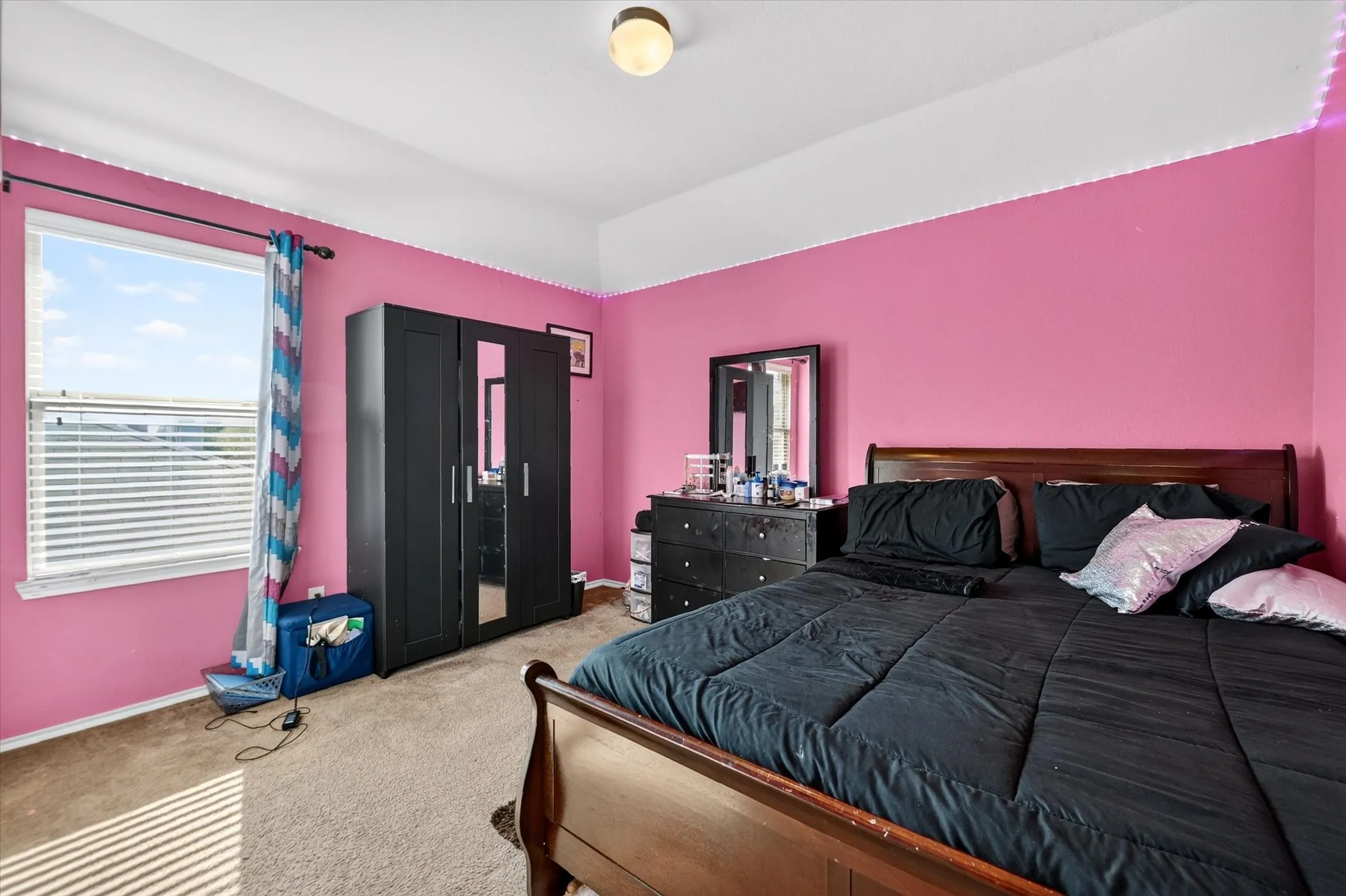 Recessed lighting with a ceiling-mounted fixture, a window with horizontal blinds, and carpet flooring