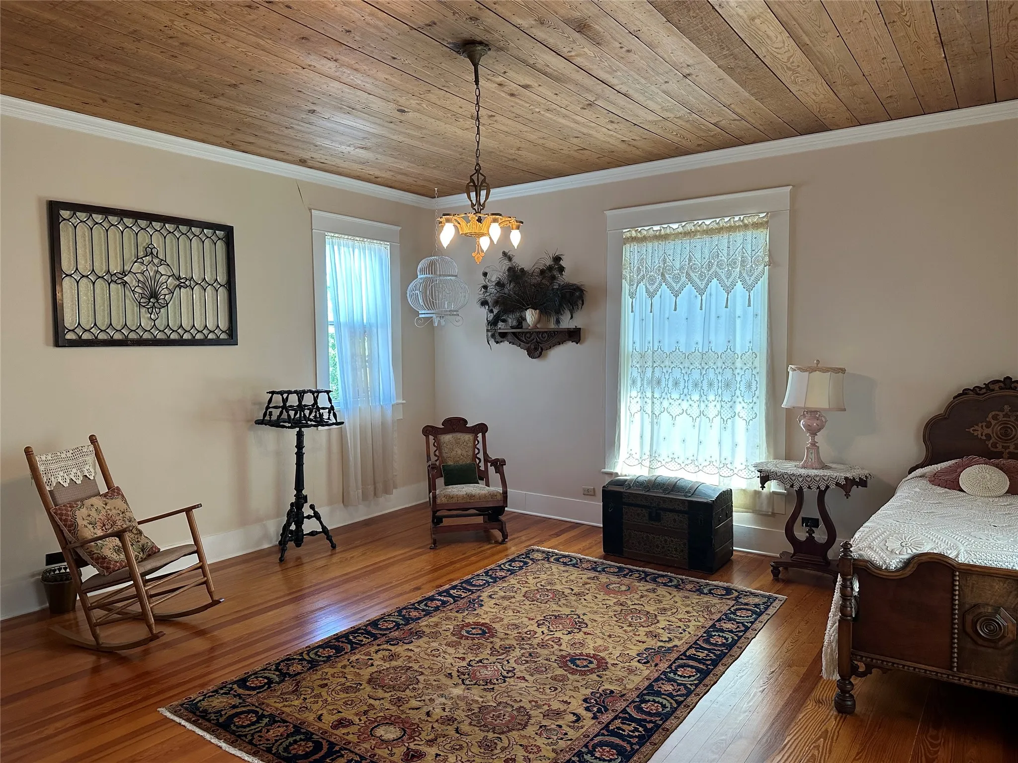 Wood-plank ceiling with a decorative chandelier, light-toned walls, and wood-finish flooring