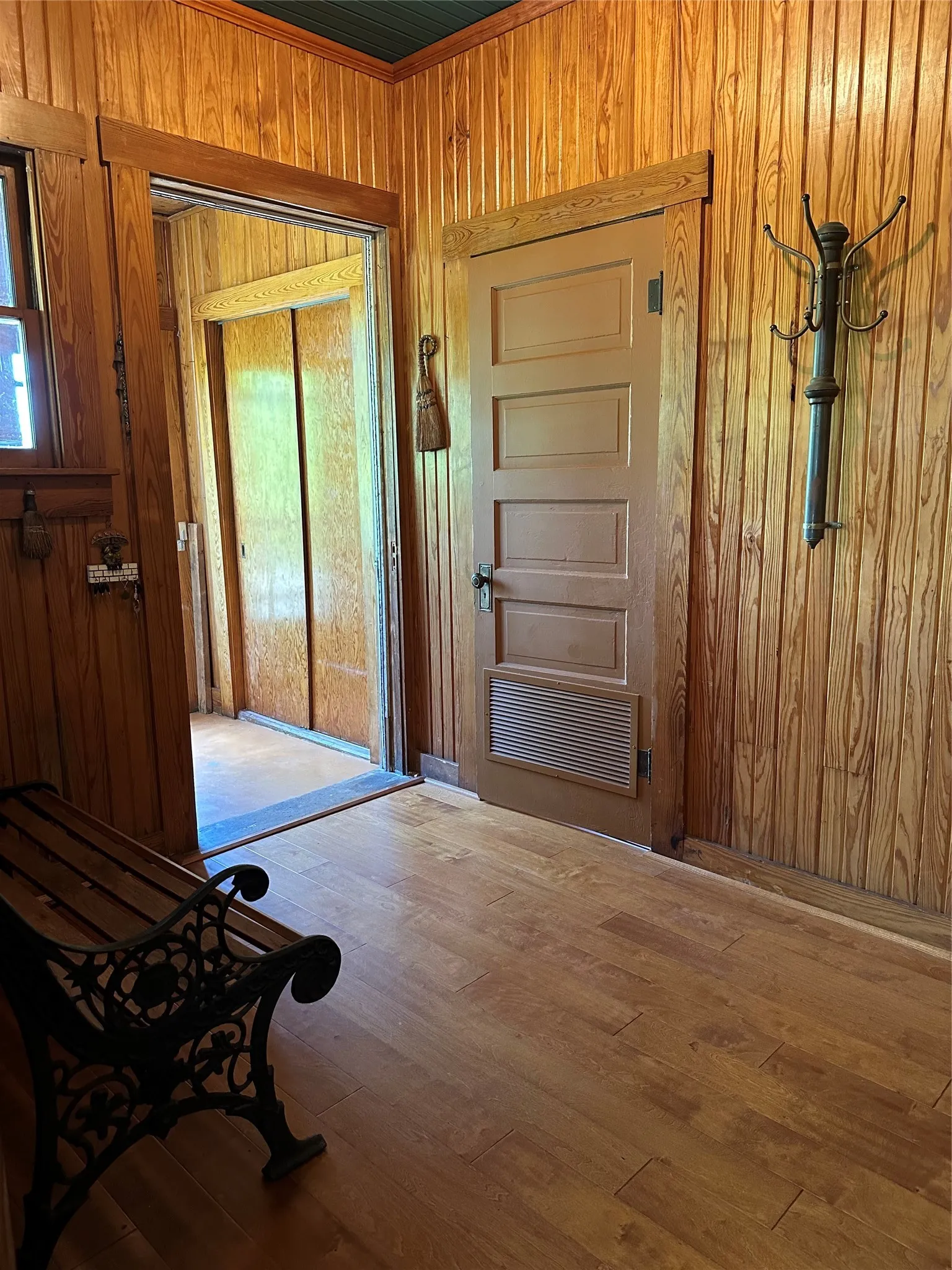 Wood-finish flooring with wood-paneled walls and trim