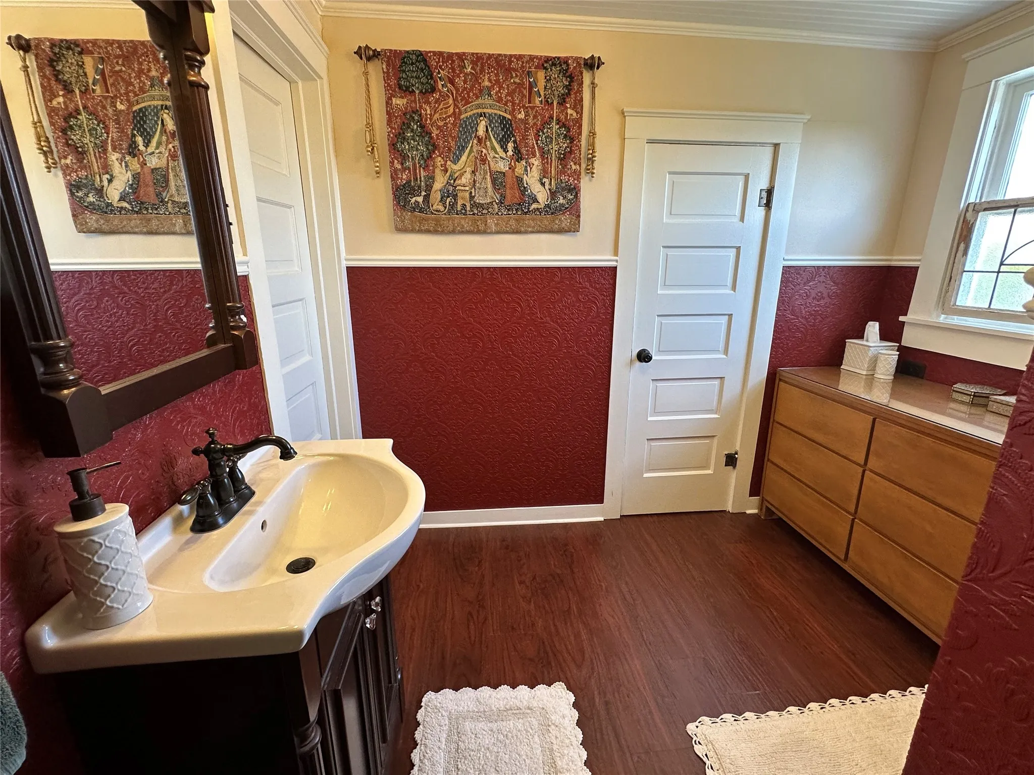 White porcelain sink with dark bronze-finish faucet, dark wood-finish vanity, and dark wood-finish flooring