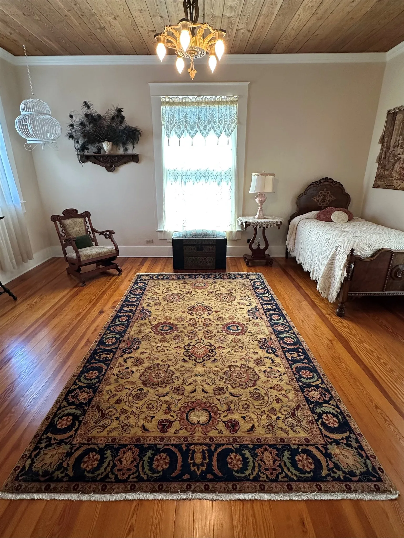 Wood-plank ceiling, rich wood flooring, and a decorative chandelier