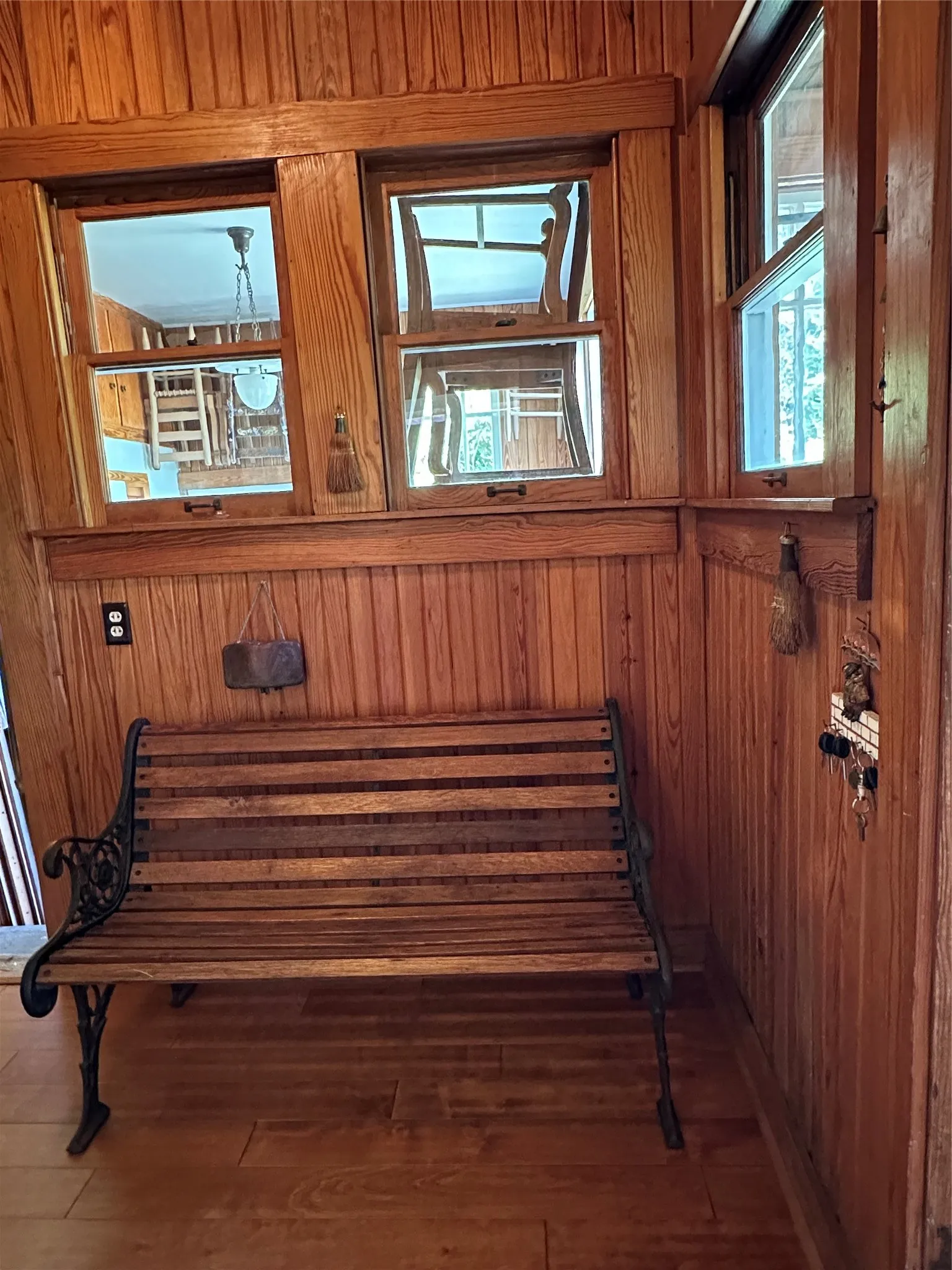 Wood-paneled walls and ceiling, wood-finish flooring, multiple windows, and decorative wood trim