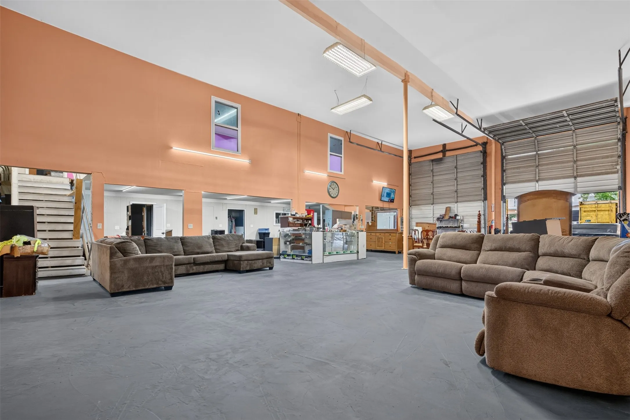 Spacious interior with high ceilings, multiple roll-up doors, and durable flooring