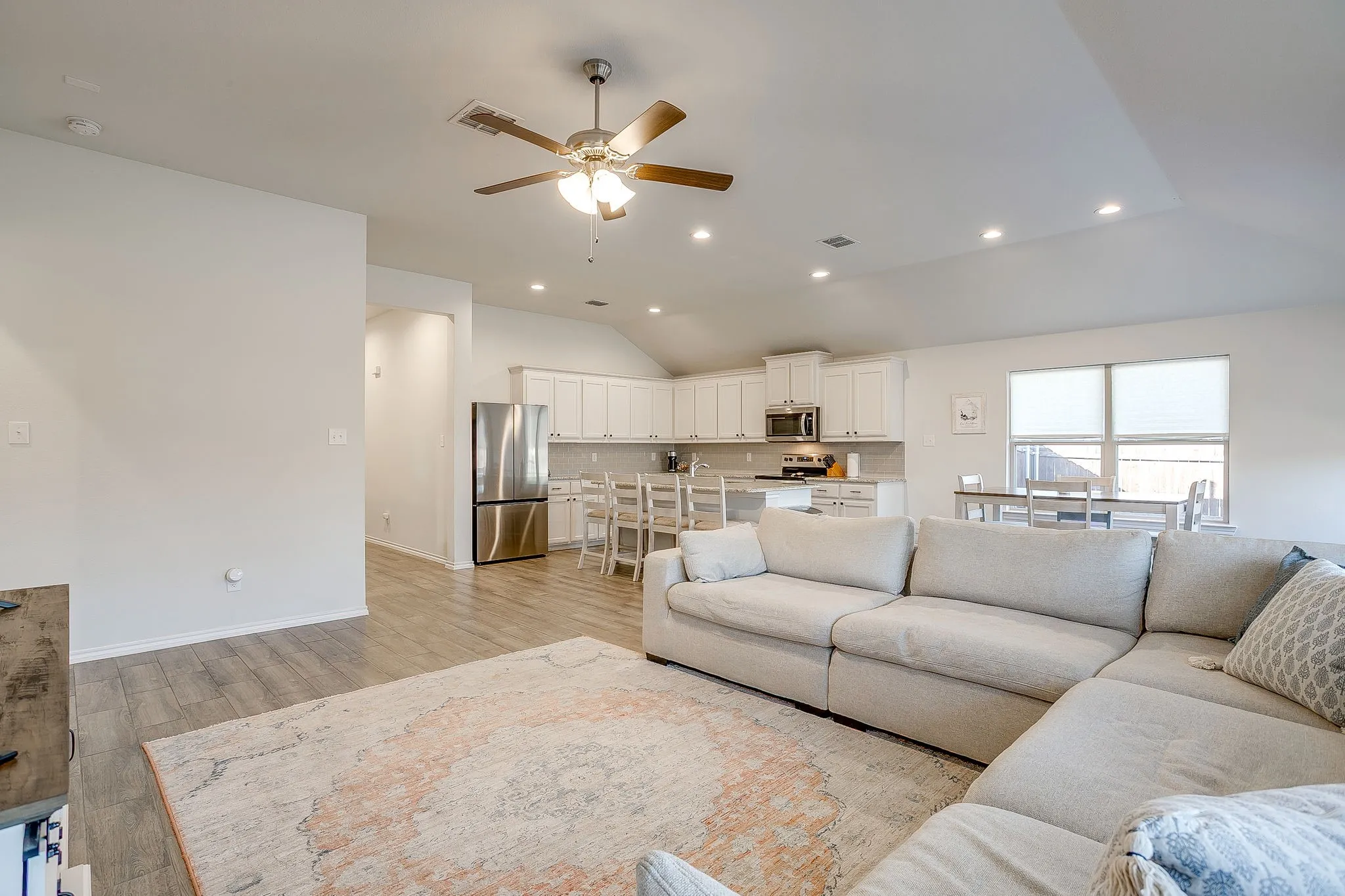 Vaulted ceiling with recessed lighting and a ceiling fan