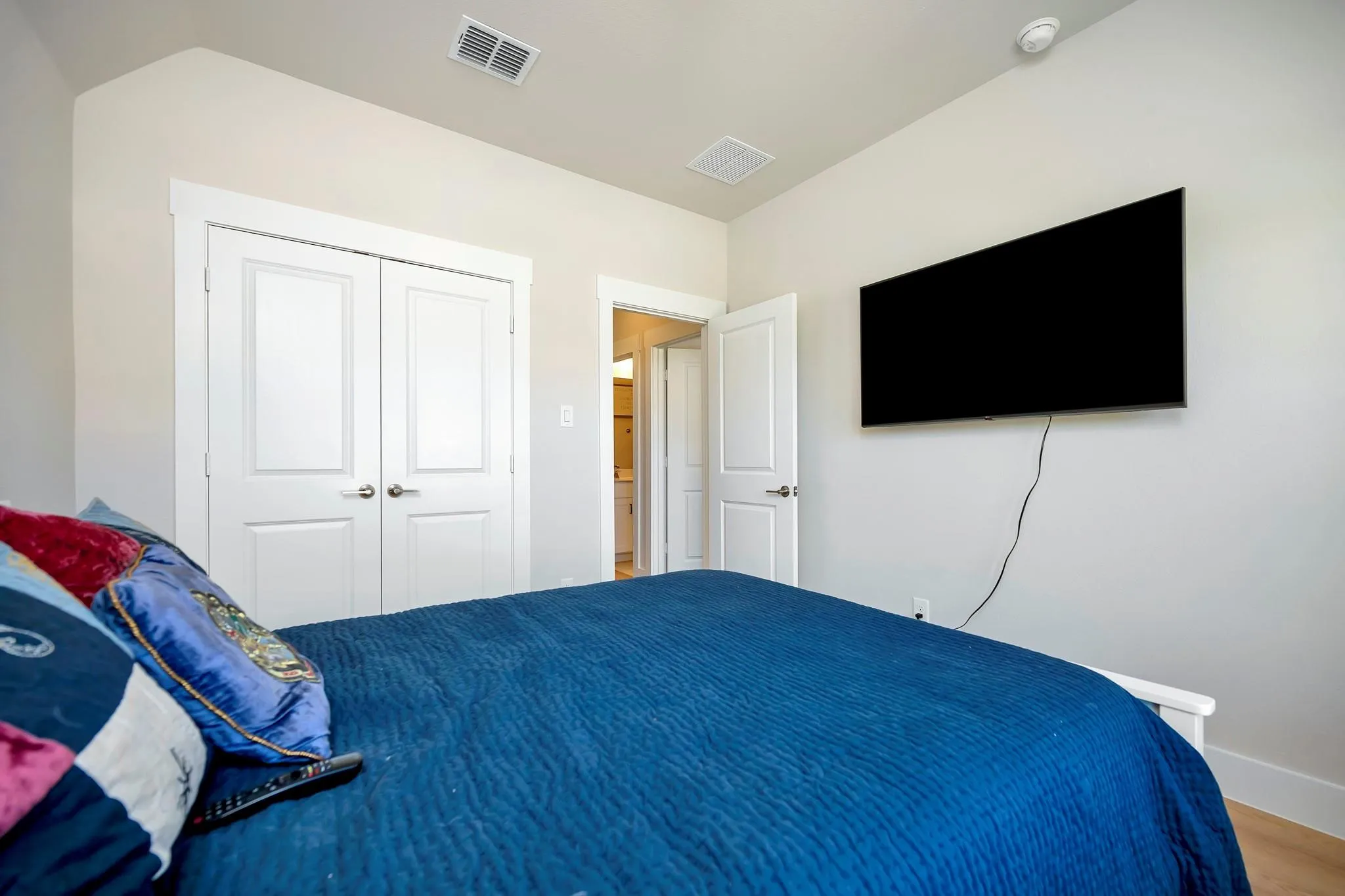Bedroom featuring neutral wall color, white trim, and a double-door closet