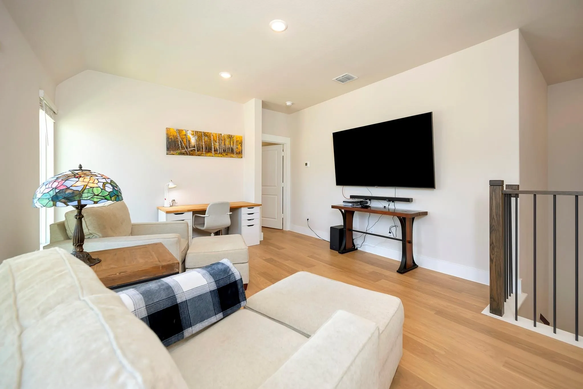 Recessed lighting, wood-finish flooring, white walls, and a wood and metal railing
