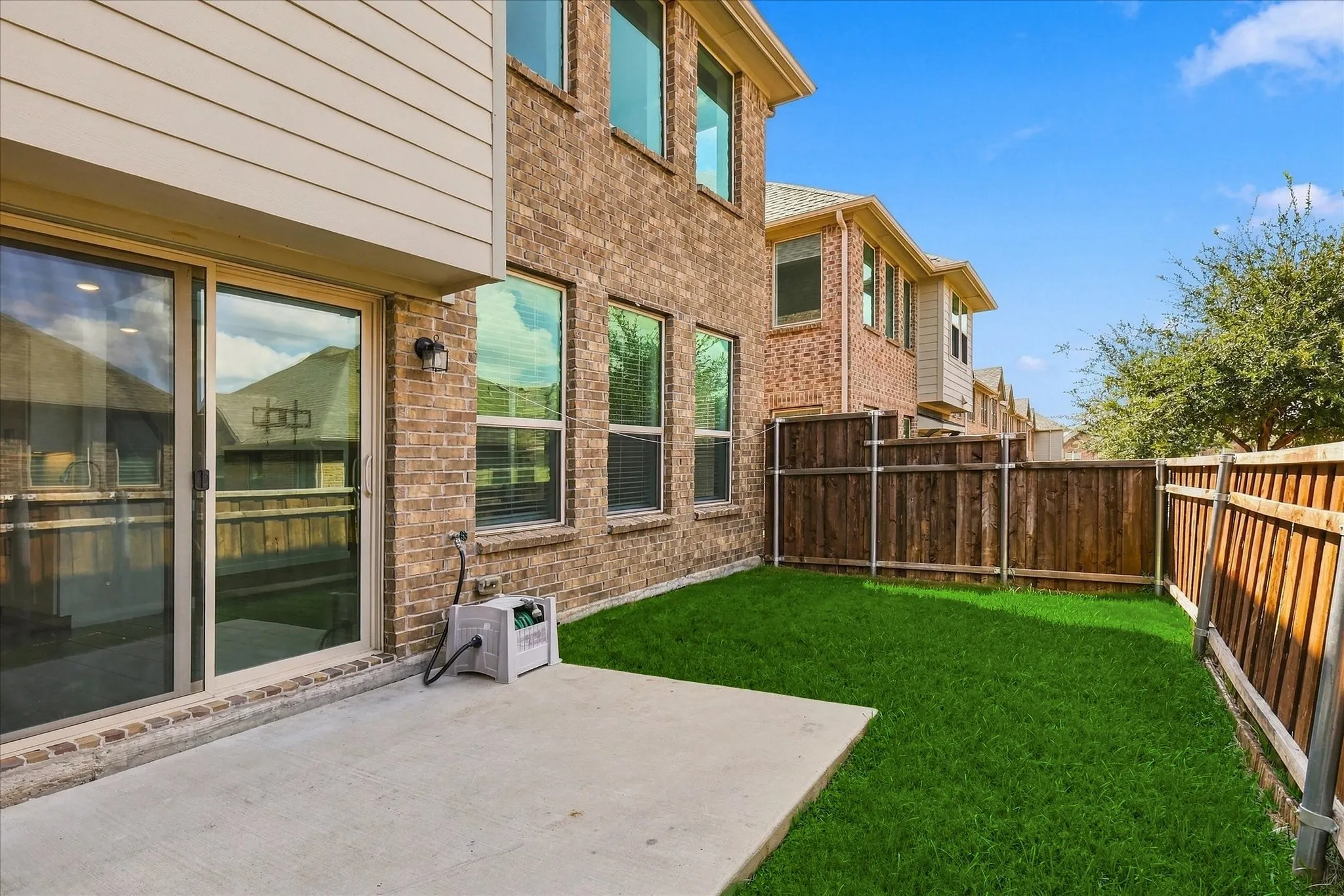 Private fenced backyard with grassy area & patio for outdoor enjoyment
