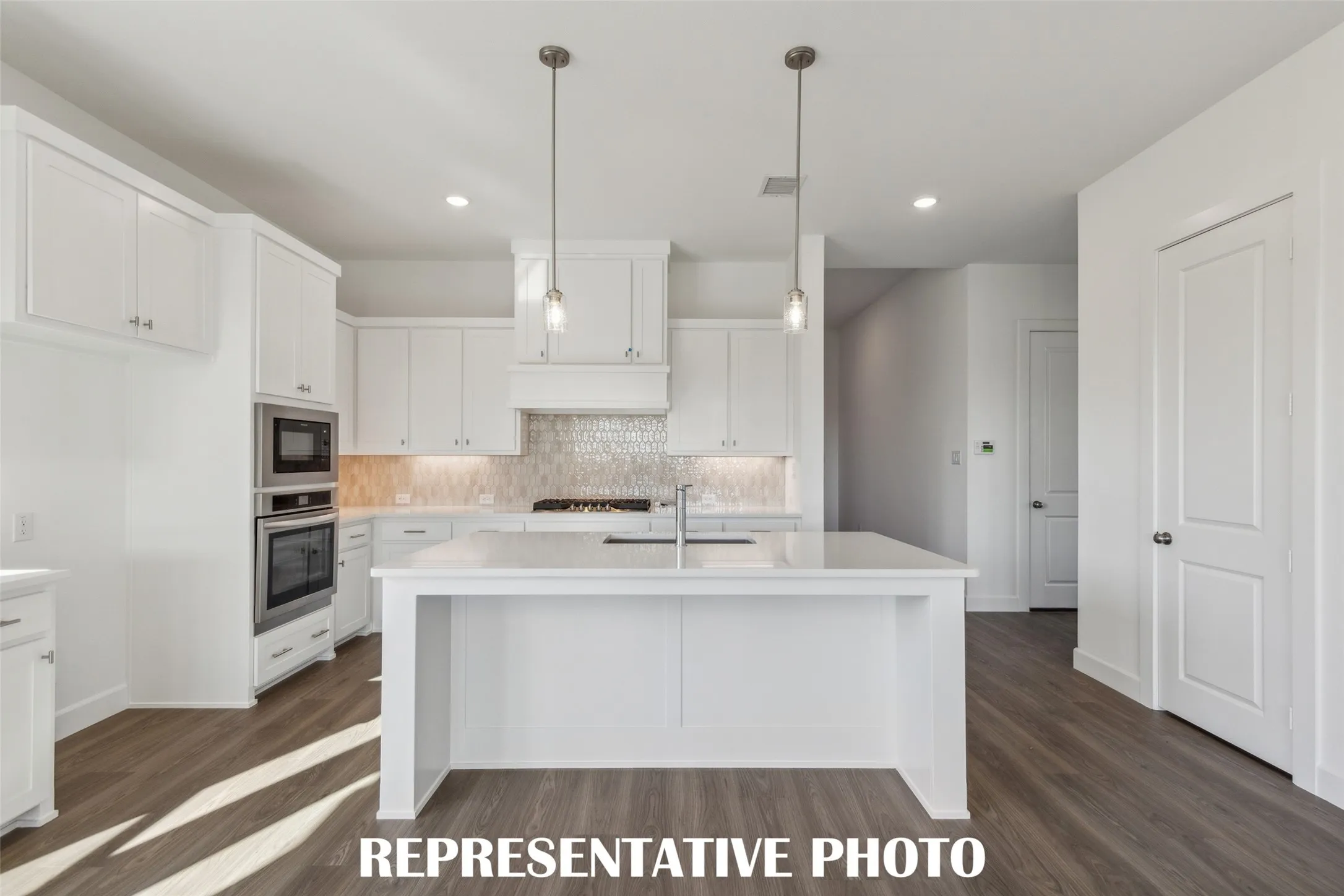The oversized kitchen island is the hub of your new dream home and the perfect place for friends and family to gather!  REPRESENTATIVE PHOTO
