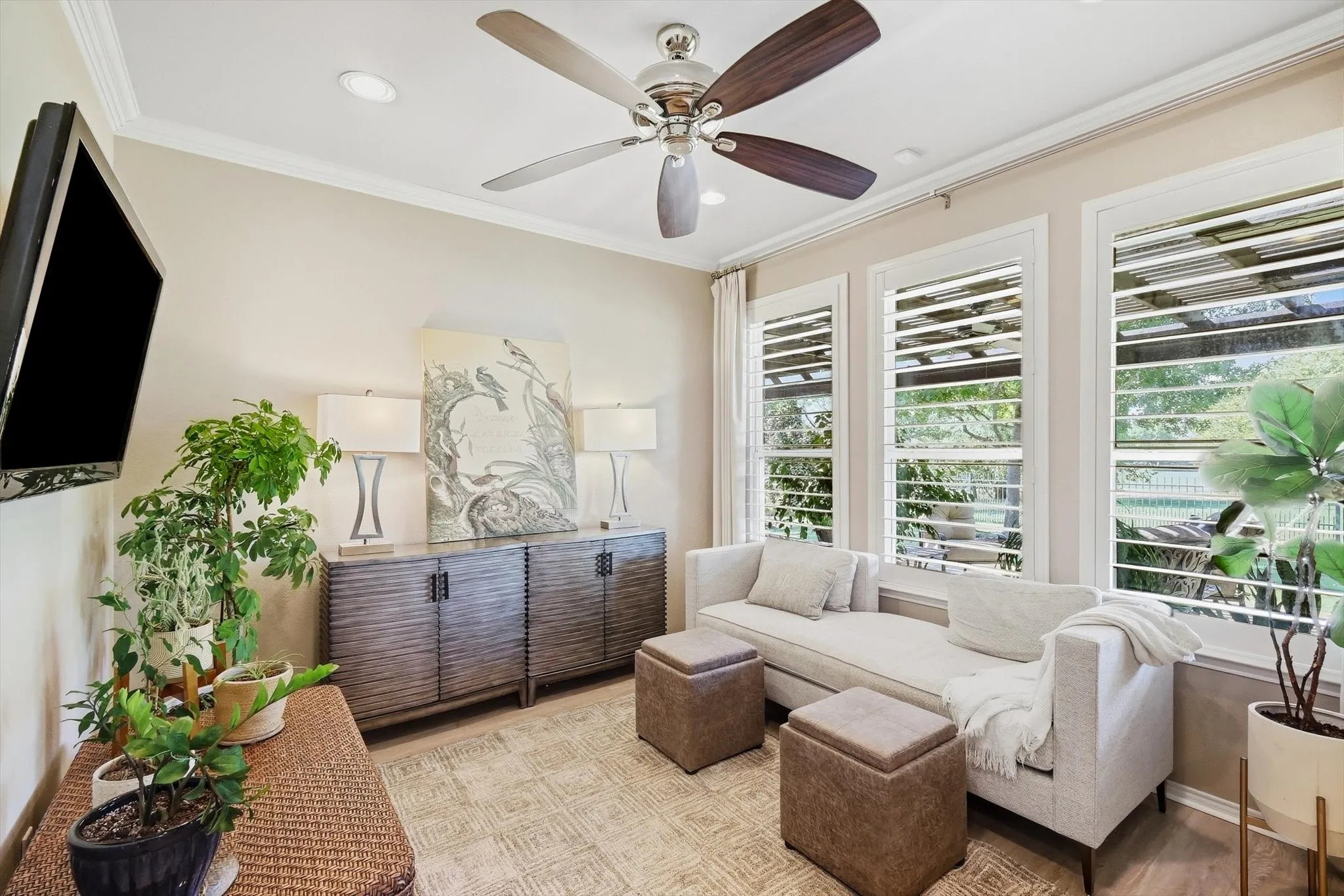 Study or secondary Living Area with Recessed lighting, crown molding, ceiling fan, natural wood-finish flooring, and white plantation shutters with great views of the beatiful landcaped backyard