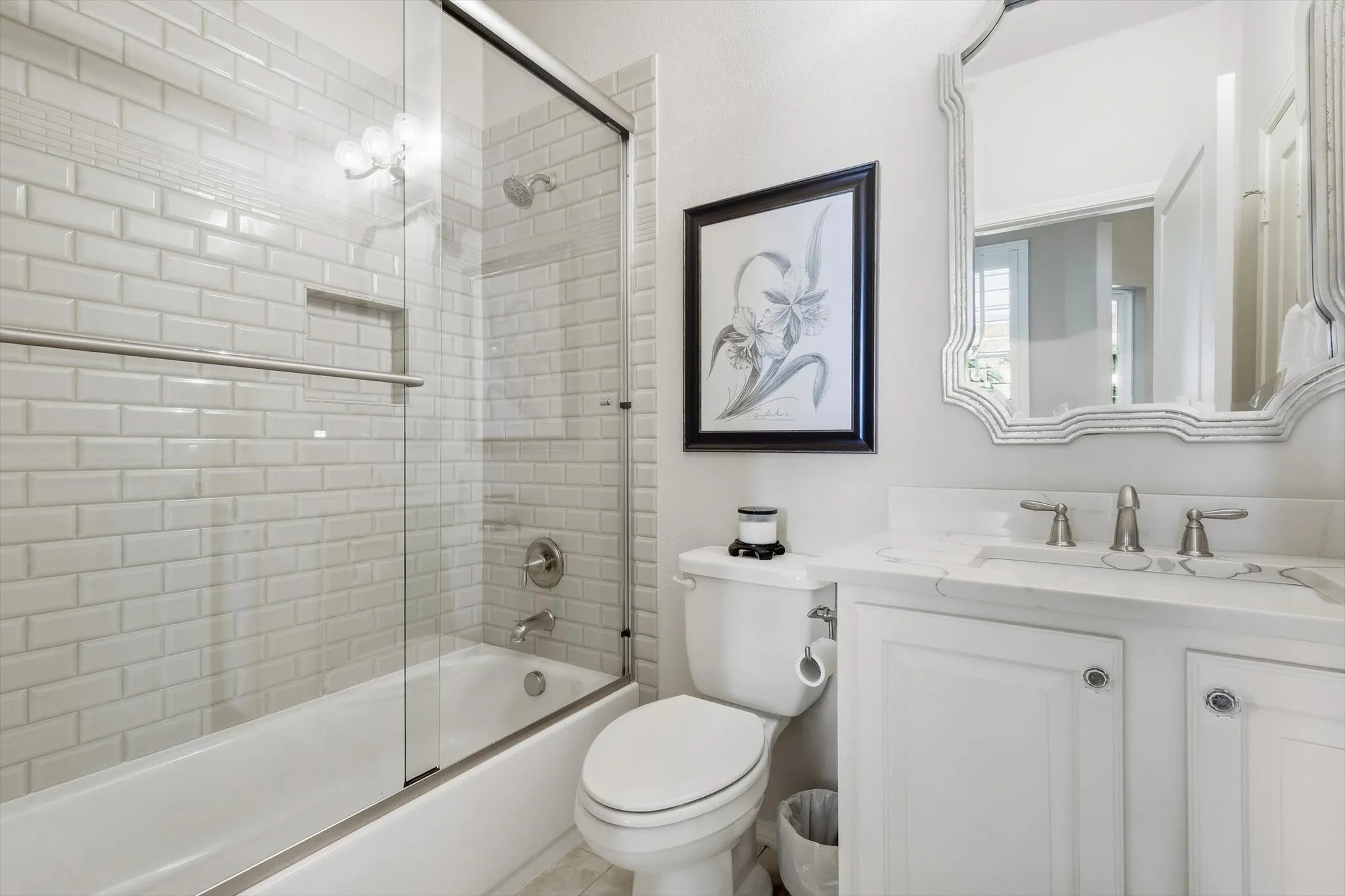 White subway tile shower surround with integrated niche, white cabinets and a Linen Closet