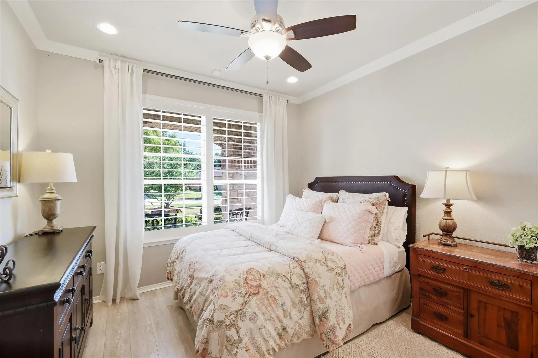 Recessed lighting, crown molding, wood-finish flooring, ceiling fan, and window with plantation shutters