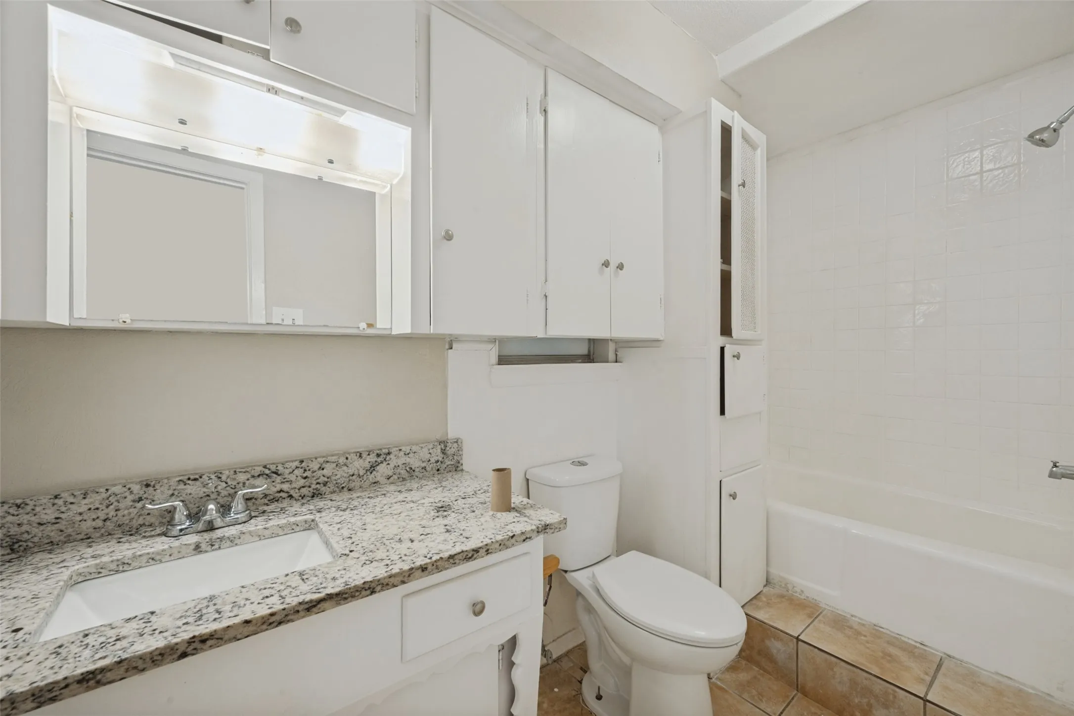 White vanity with integrated sink, speckled countertop, and chrome faucet