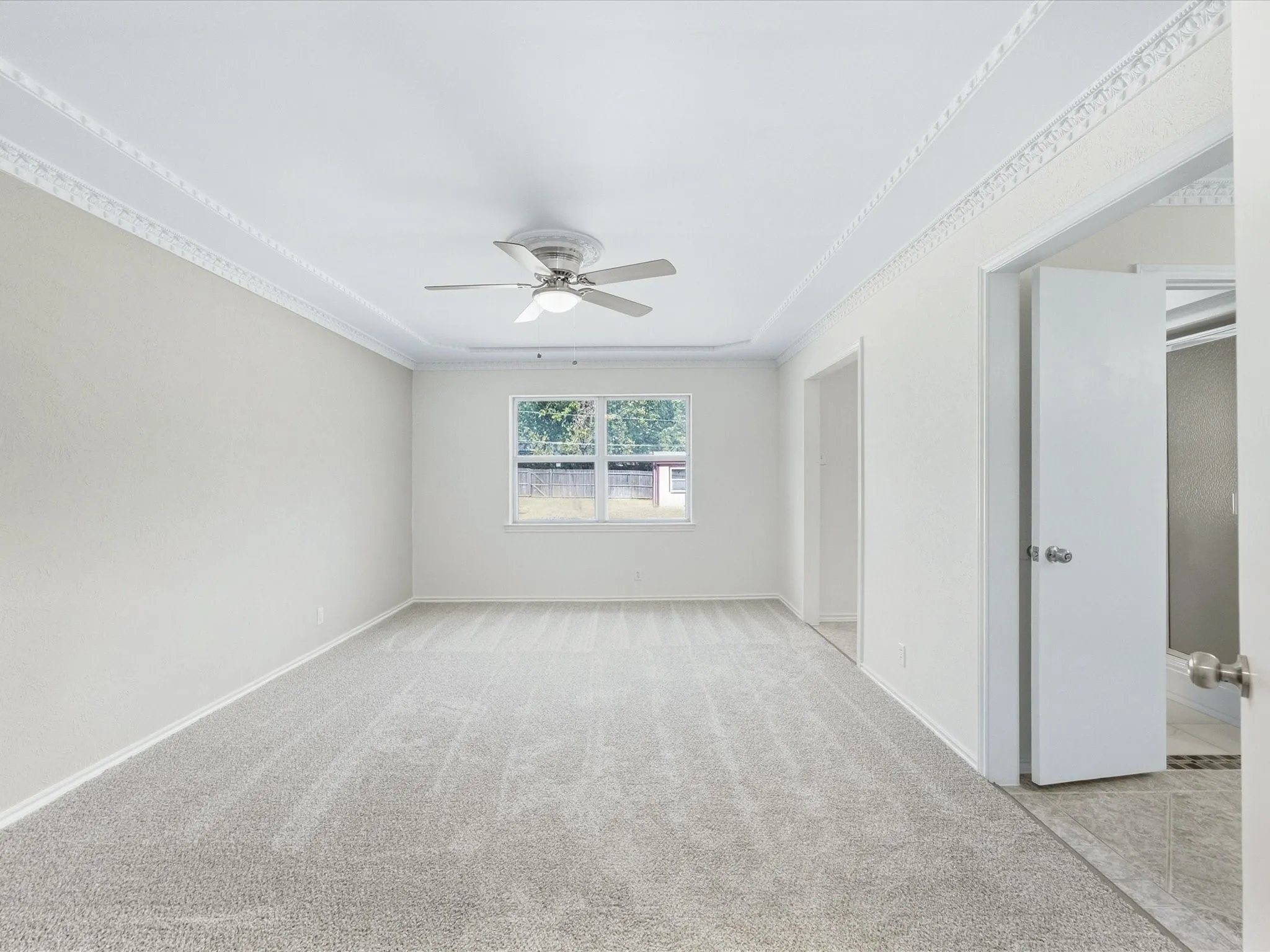Neutral wall finishes, recessed ceiling detail, and a ceiling fan with integrated lighting