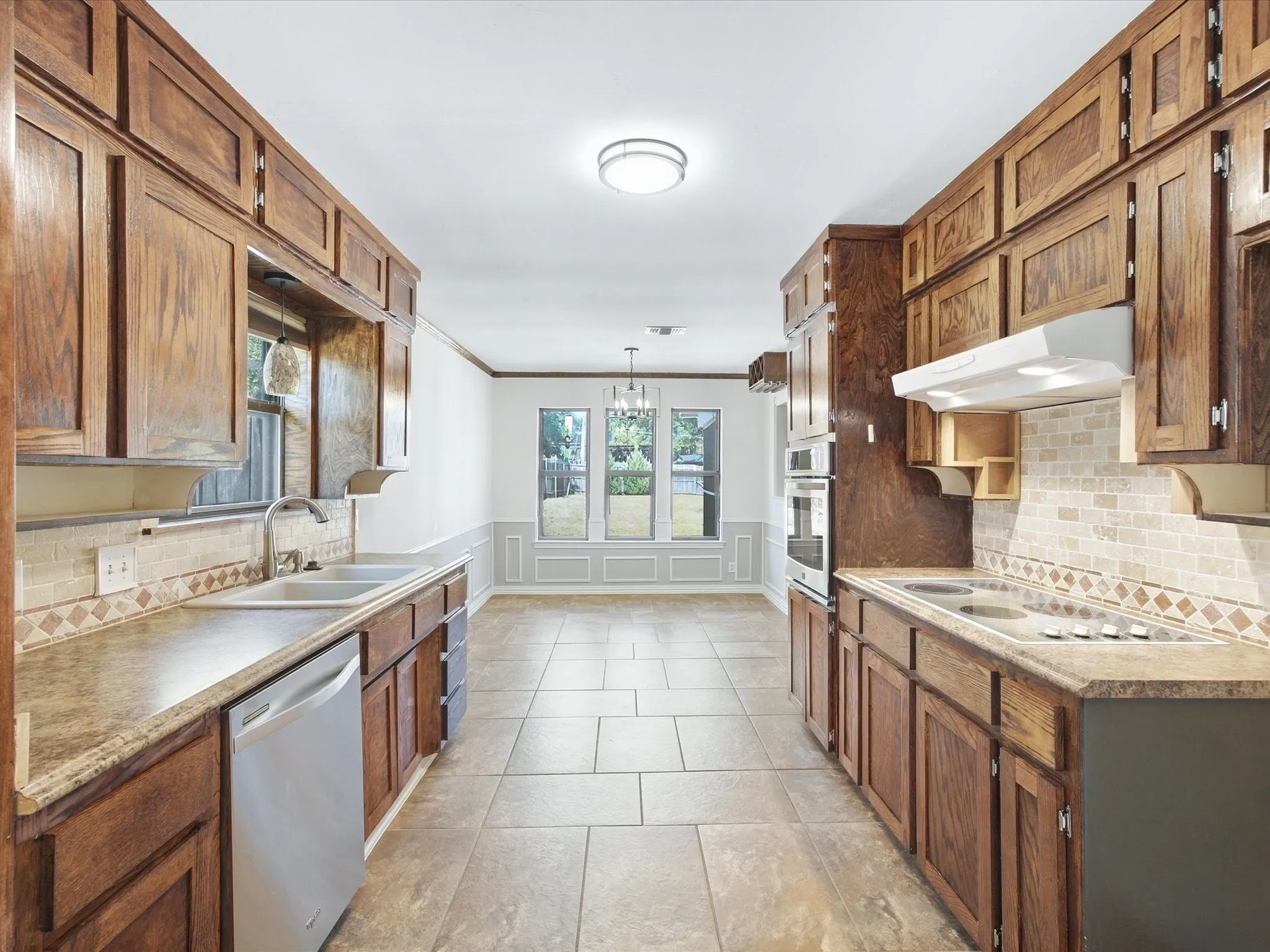 Kitchen featuring wood cabinetry, stone-finish countertops, and a tile backsplash