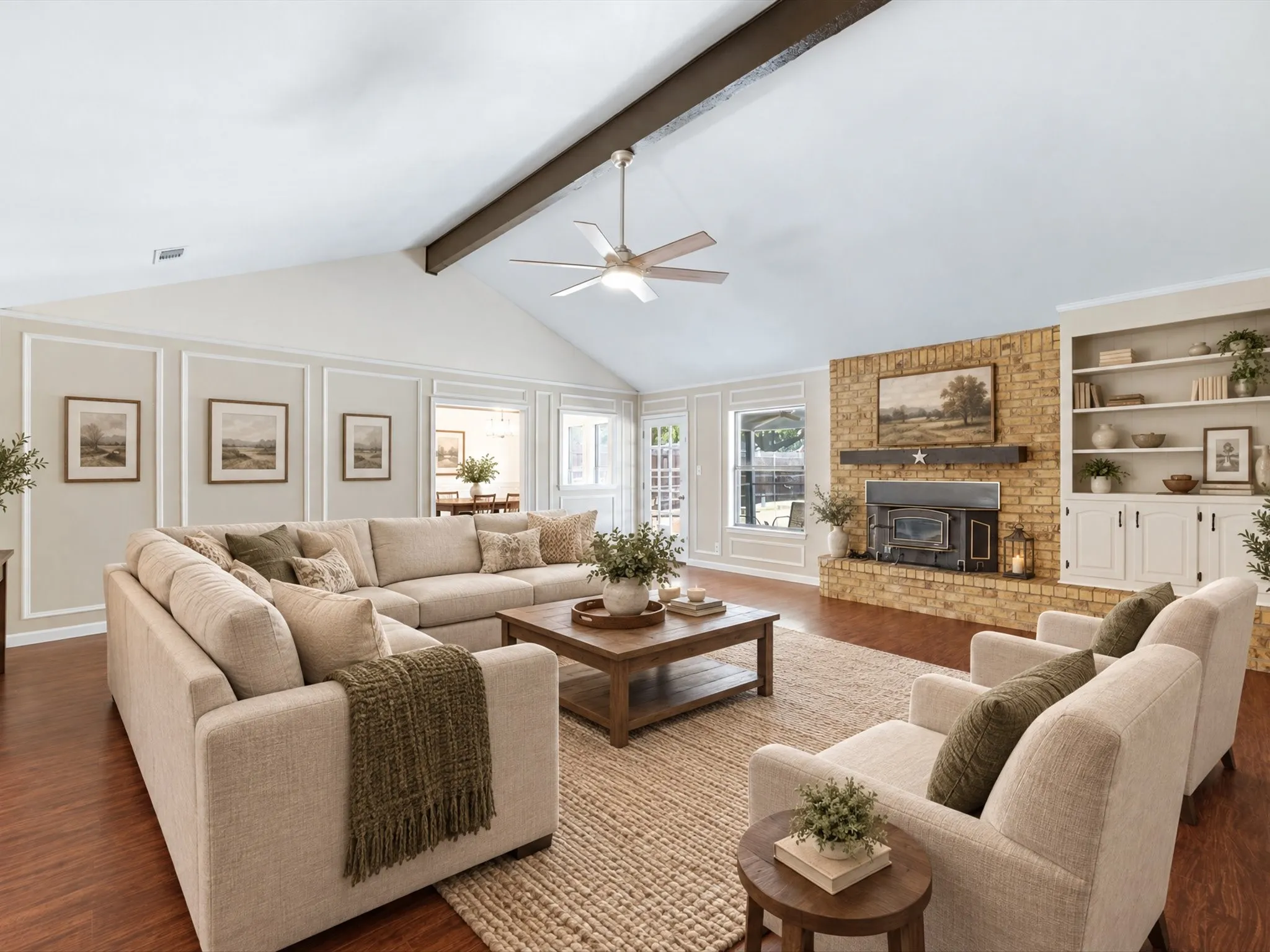 VIRTUALLY STAGED! Vaulted ceiling with exposed wood beam, wood-finish flooring, brick-surround fireplace with wood mantle, built-in shelving and cabinetry, and decorative wall molding
