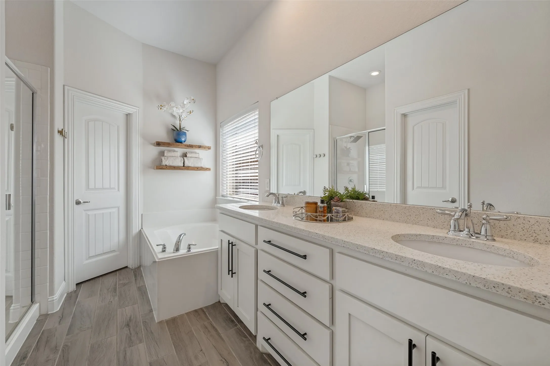 Dual vanity with integrated sinks, light-toned countertop, and dark hardware