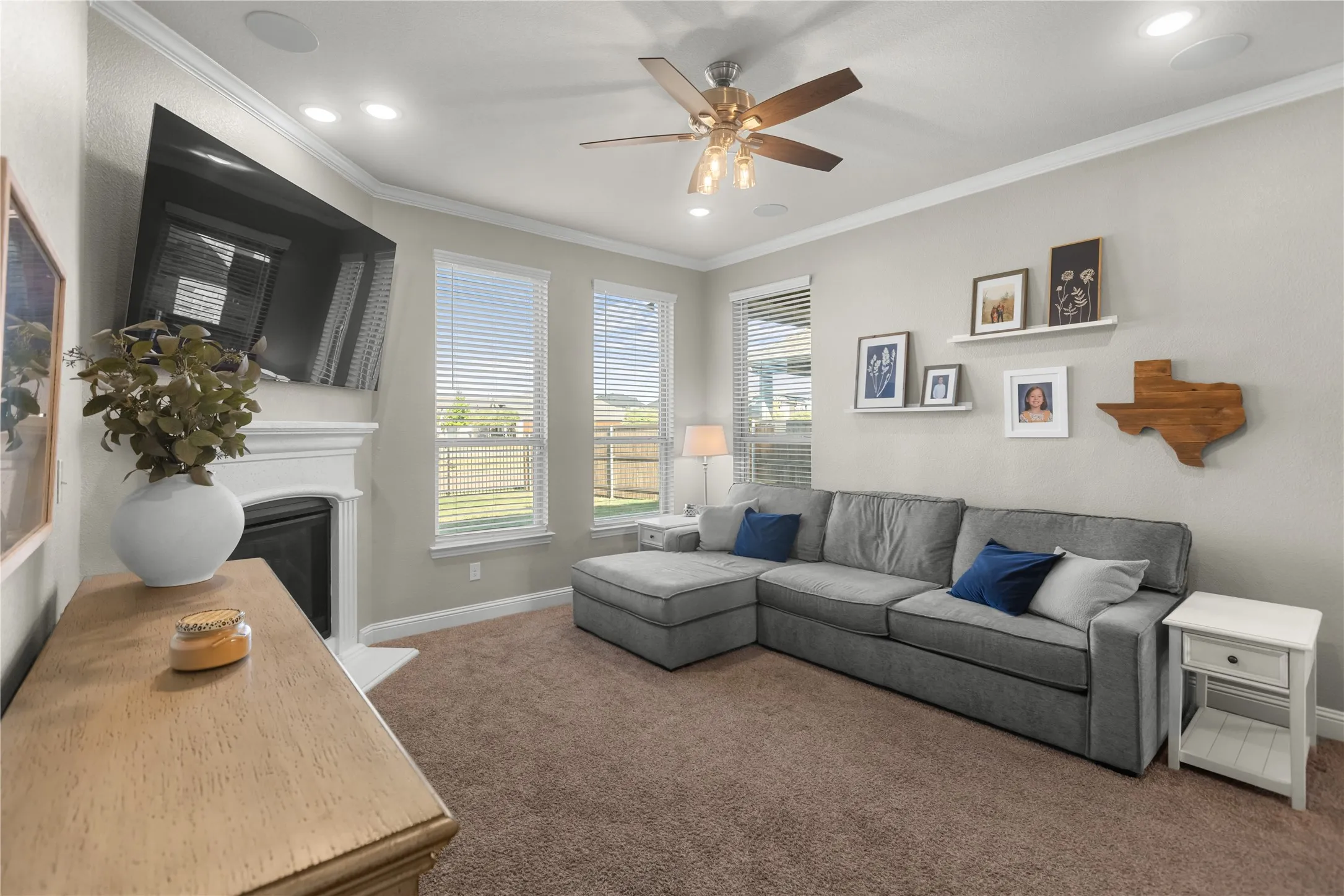 Main floor living room featuring a fireplace, tons of natural lighting, and a built-in surround sound speakers.