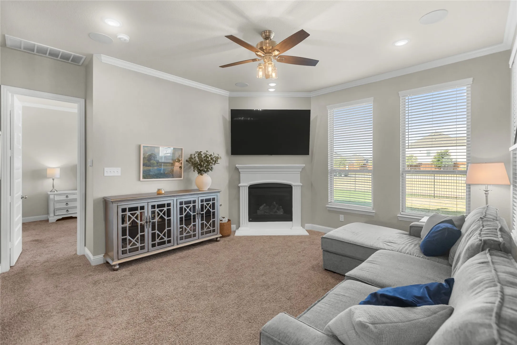 Main-floor living room featuring a cozy fireplace and views overlooking the backyard.