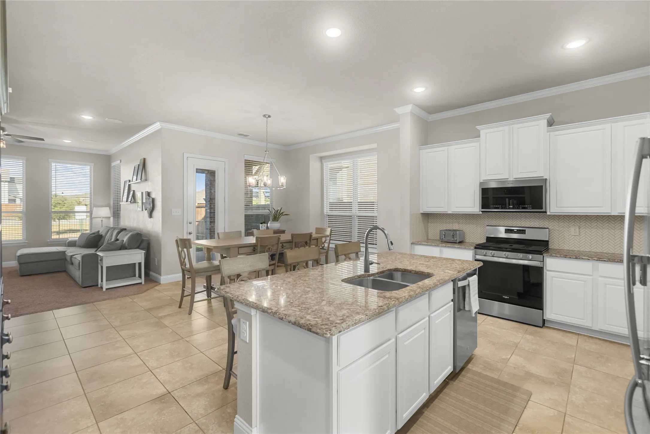 Spacious kitchen with stainless steel appliances, gas range, and island designed for gathering.