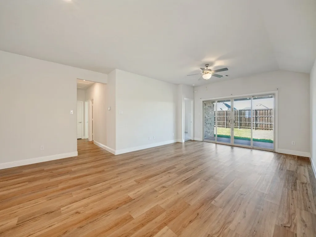 Wood-finish flooring throughout, vaulted ceiling, recessed lighting, and sliding glass doors to the backyard