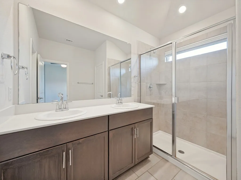 Dual vanity with white countertop, chrome fixtures, and dark wood cabinetry
