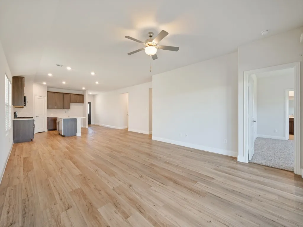 Open-concept living space with wood-finish flooring, recessed lighting, and a ceiling fan