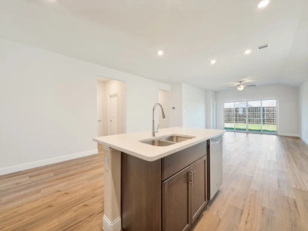 Kitchen island with a double basin sink, stainless steel faucet, and integrated dishwasher