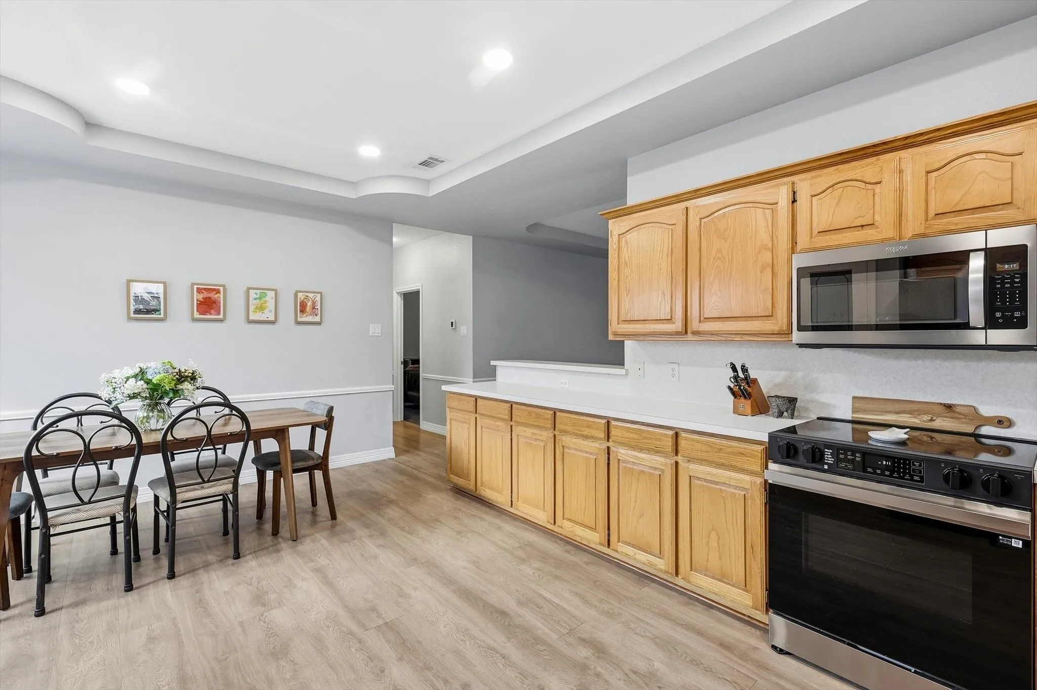 Kitchen features generous cabinet and counter space, tray ceilings, and recessed lighting