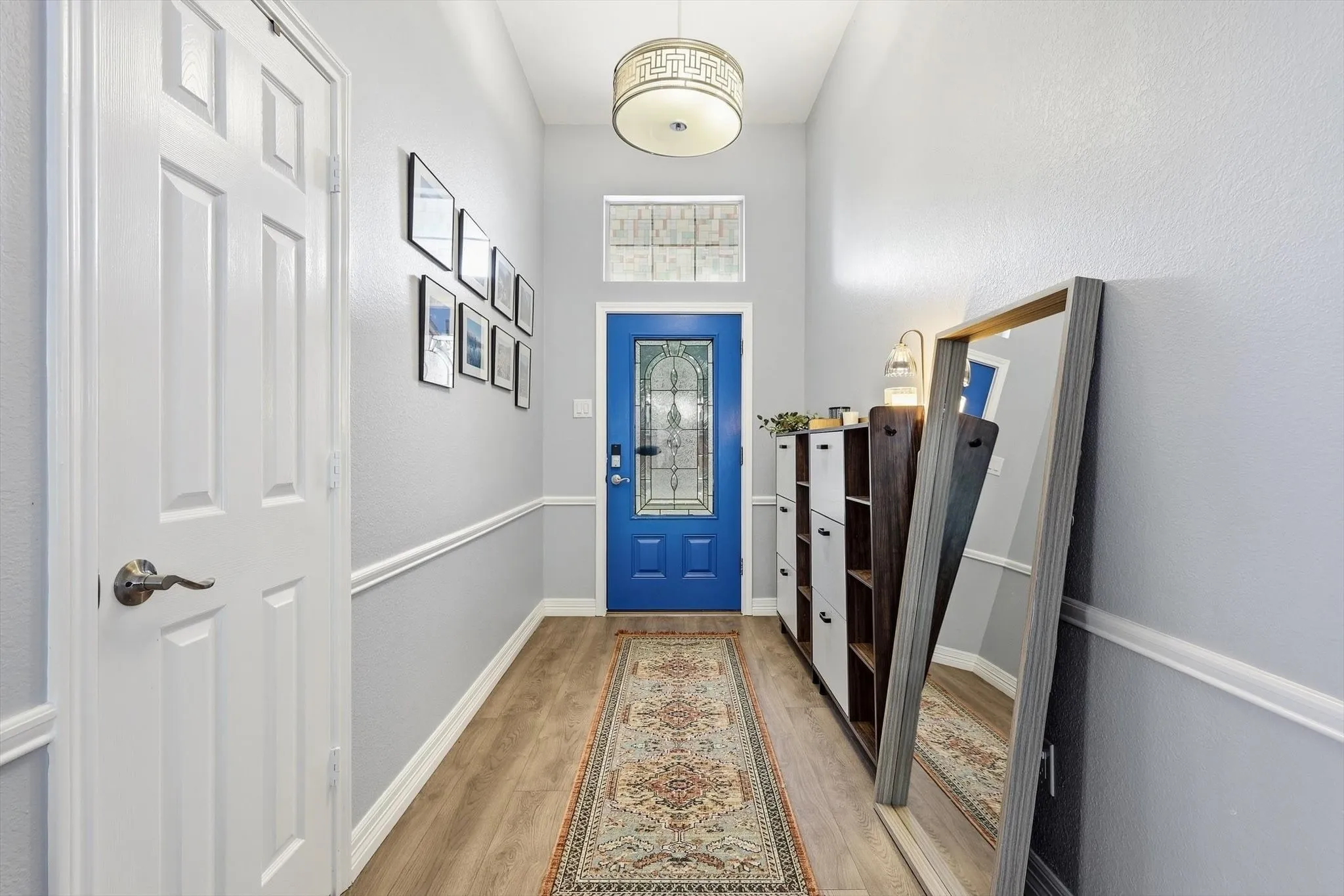 As you enter, you are greeted by a foyer entrance with decorative lighting and coat closet for easy convenience