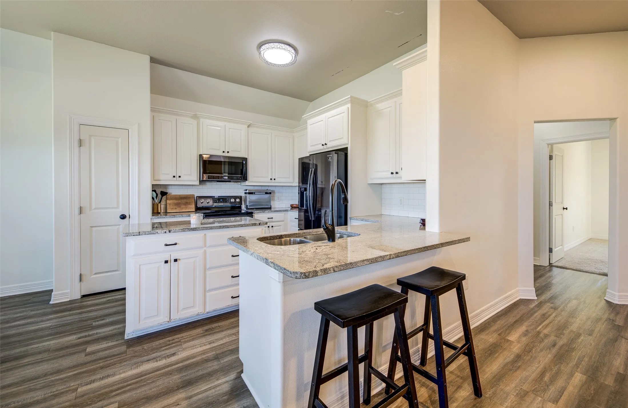 Kitchen from living room with granite counter tops.