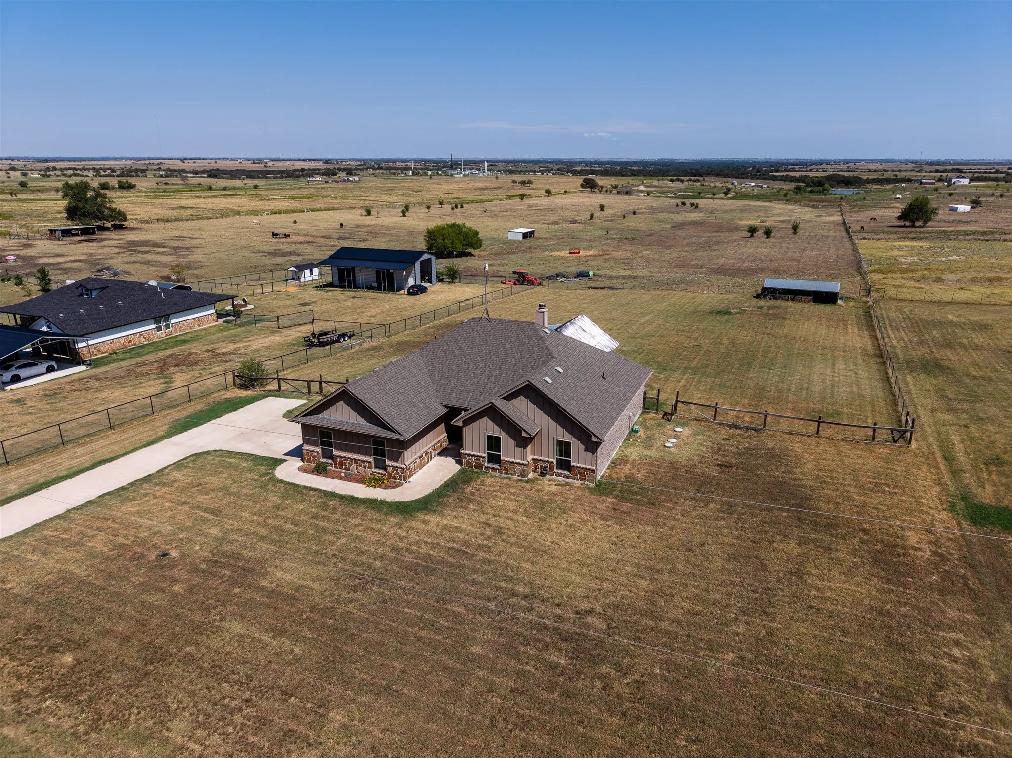 Aerial view of front of the home, back yard and the pasture behind the home.