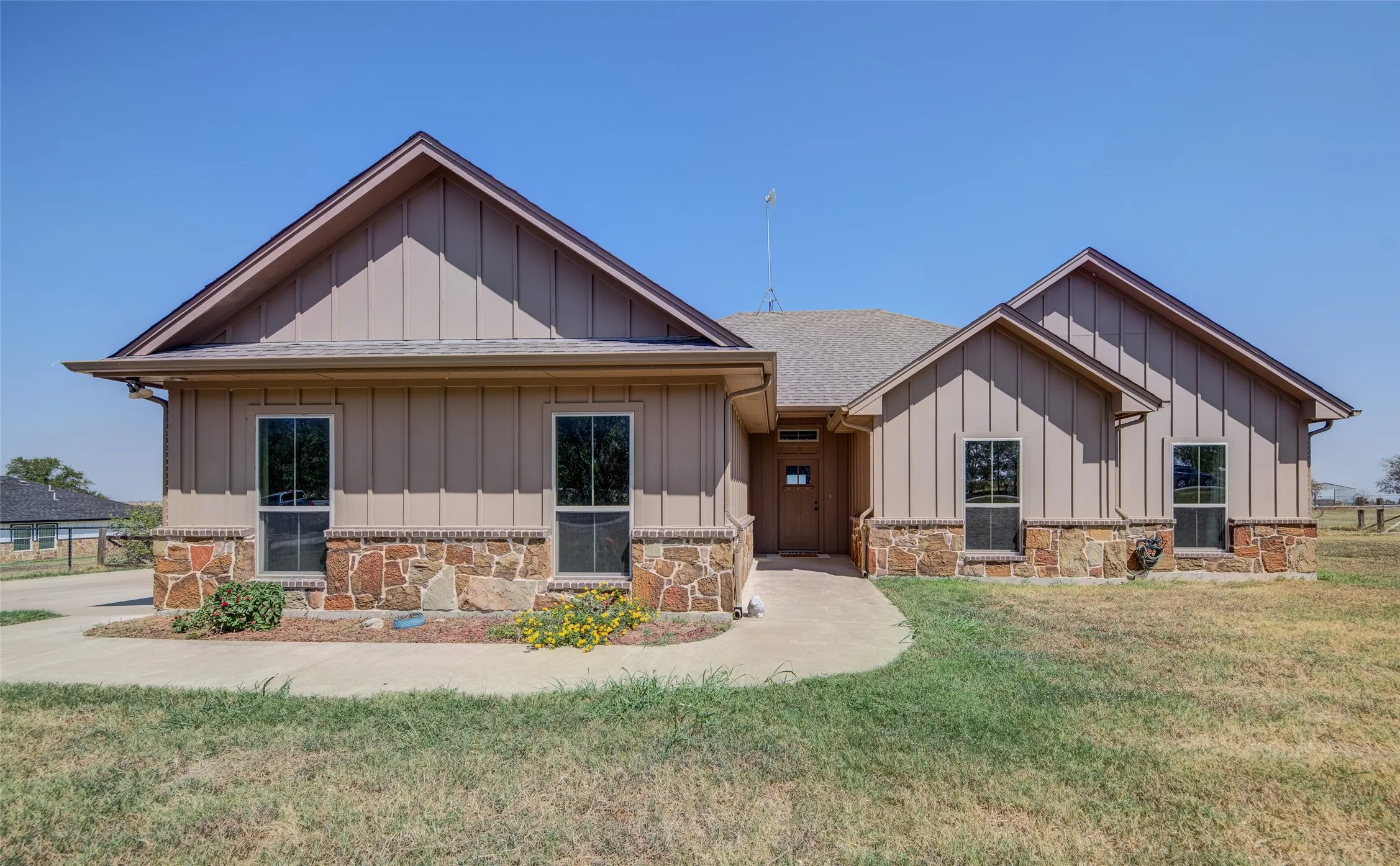 Front of home With stone and board and batten siding.