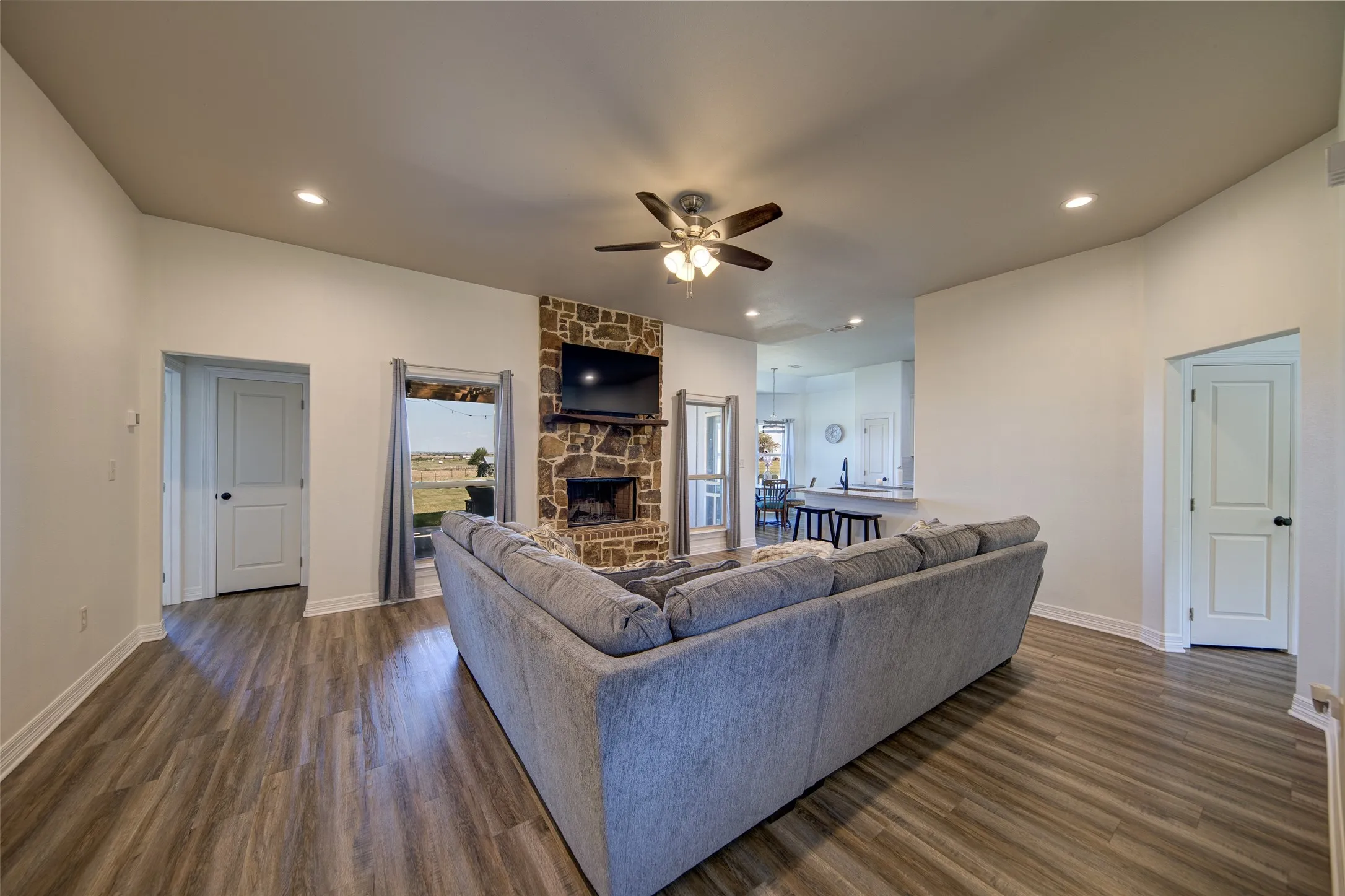 Living room with stone wood burning fireplace and view of back yard.
