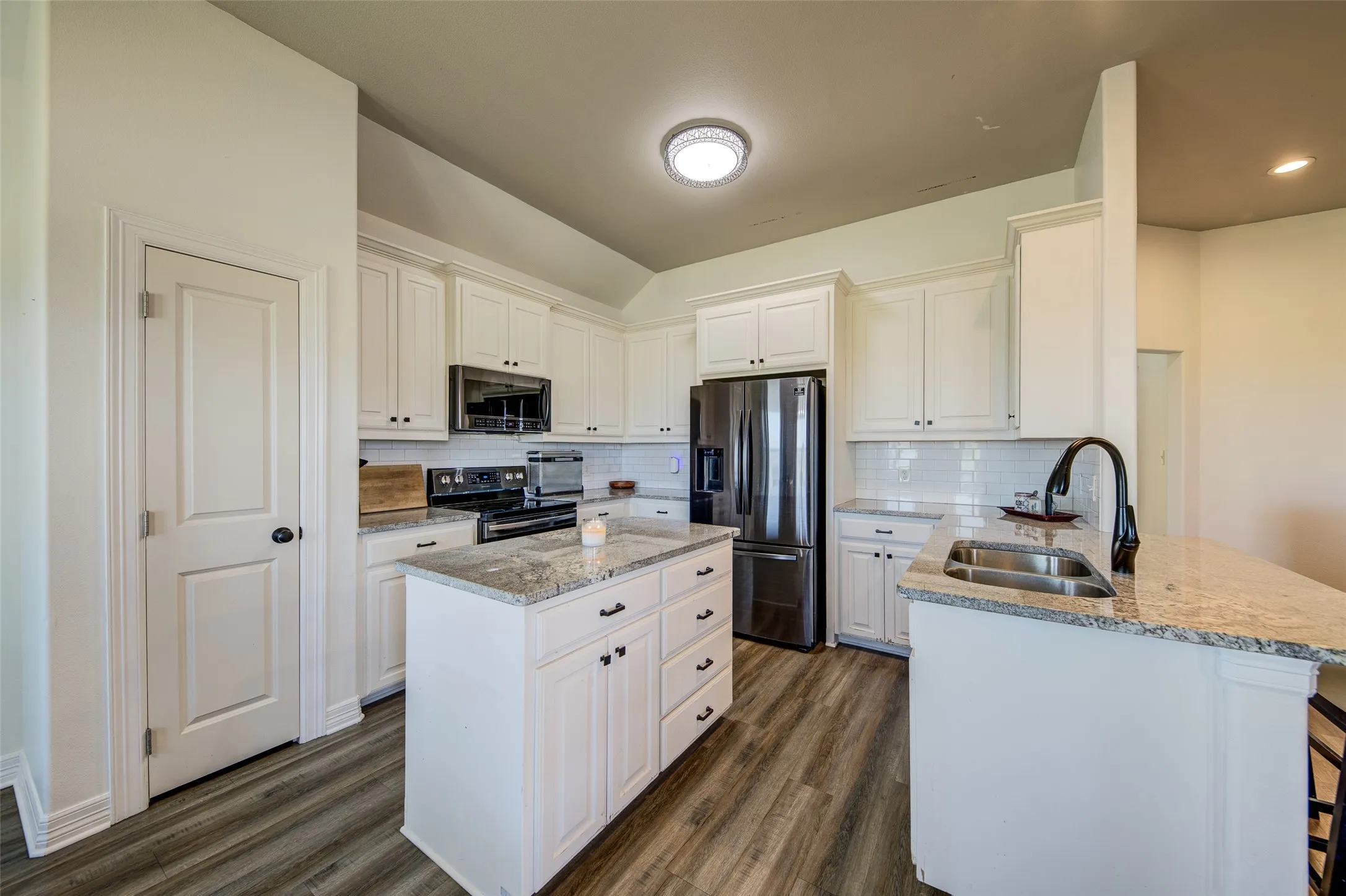 Kitchen with white cabinet and black hardware.