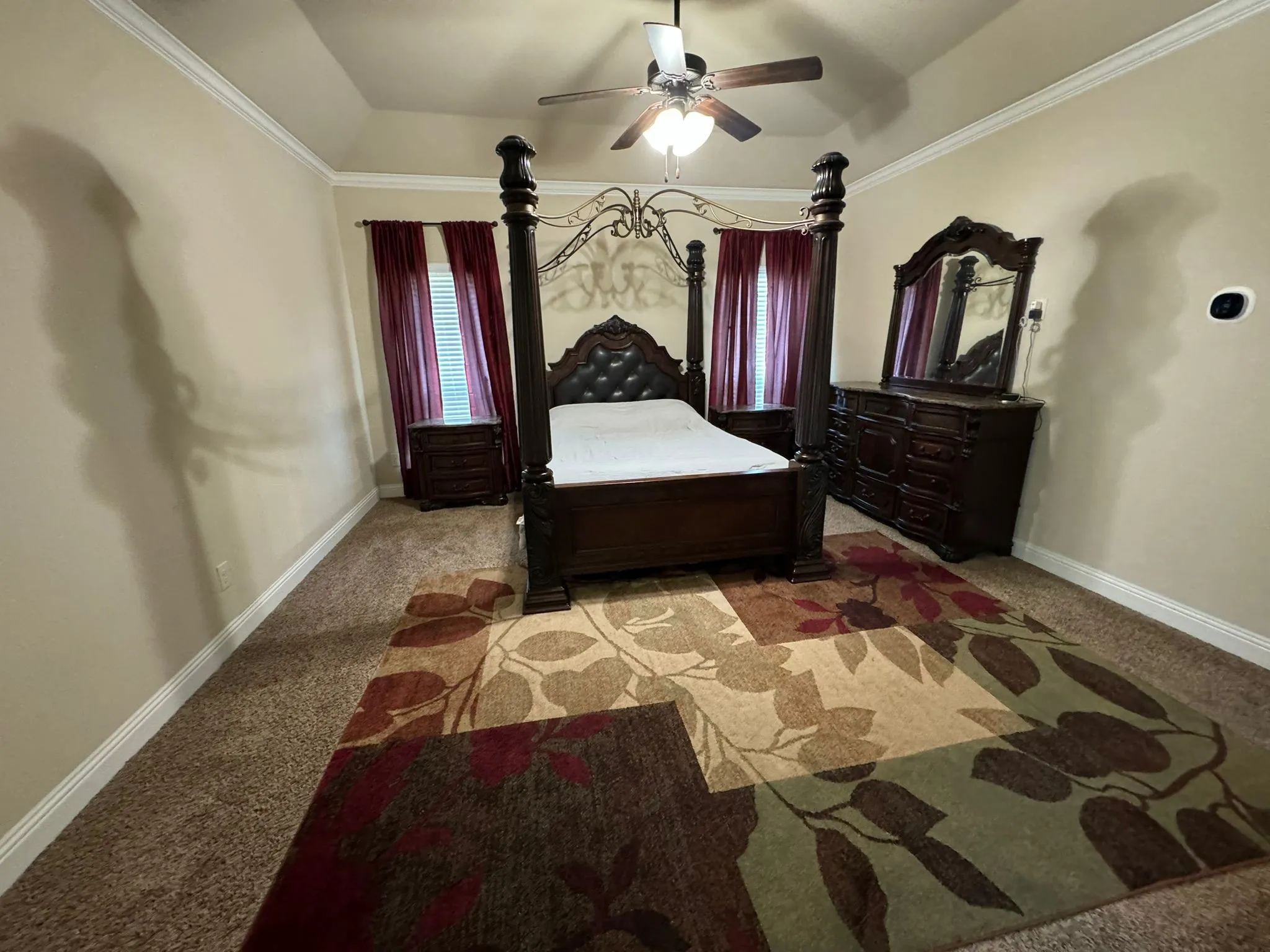 Carpeted bedroom featuring ceiling fan