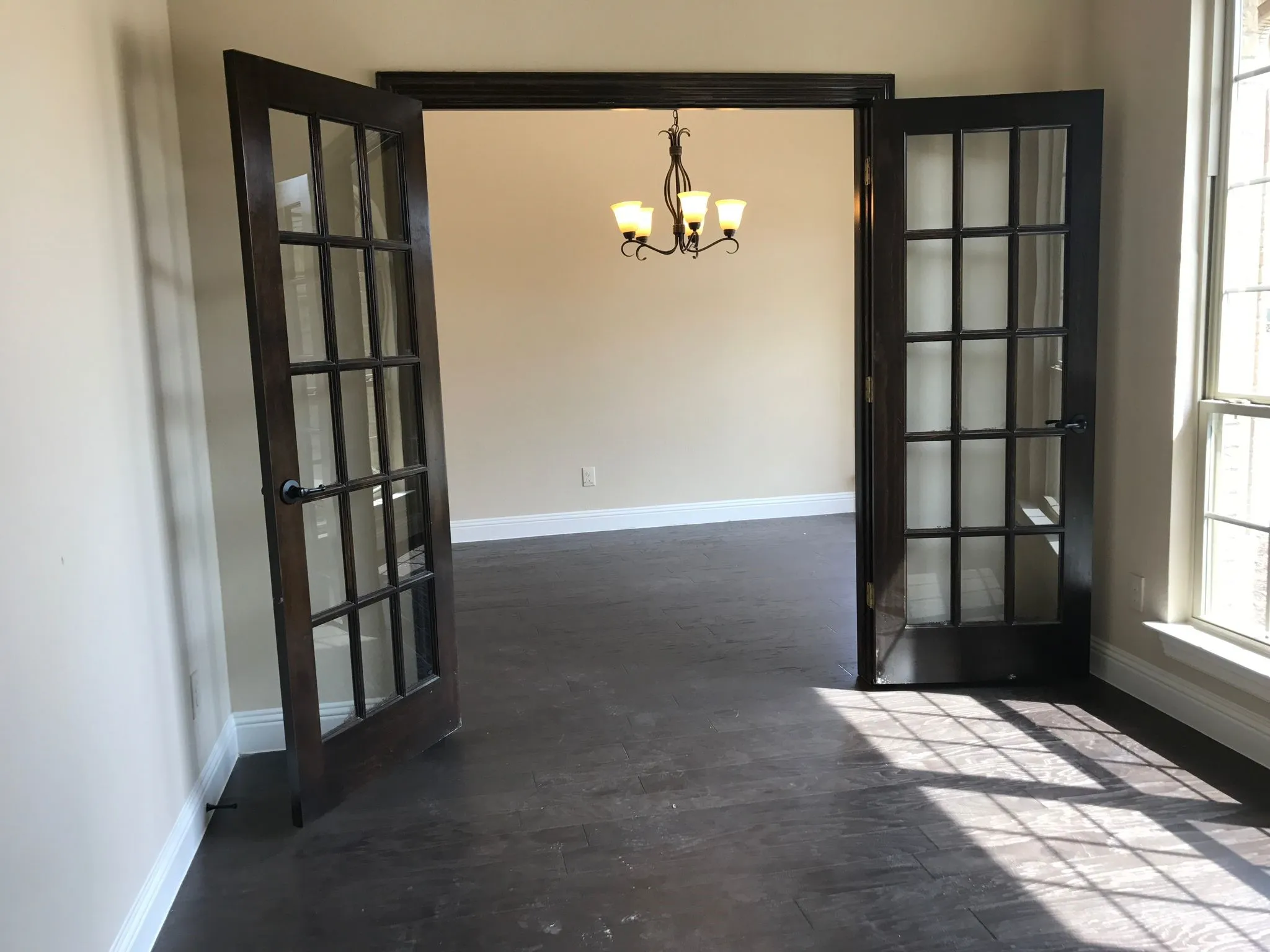 Unfurnished room with a notable chandelier and french doors