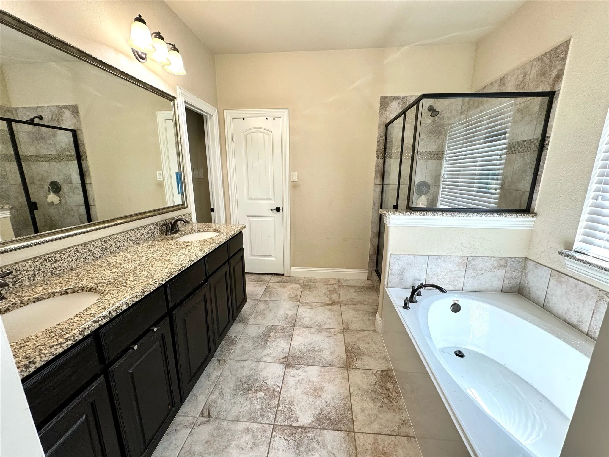 Bathroom featuring double vanity, separate shower and tub, and tile patterned floors