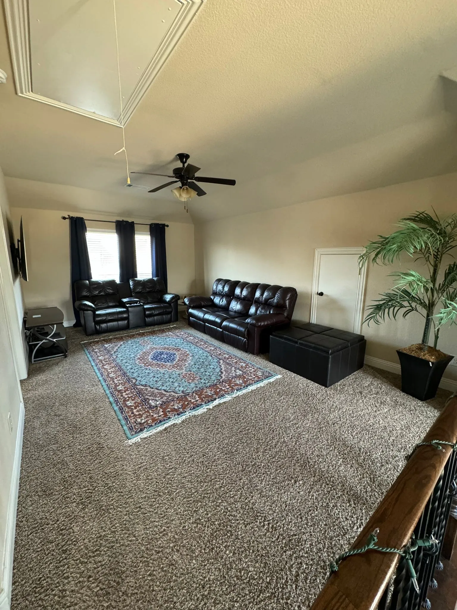 Living room featuring carpet flooring, a textured ceiling, and ceiling fan
