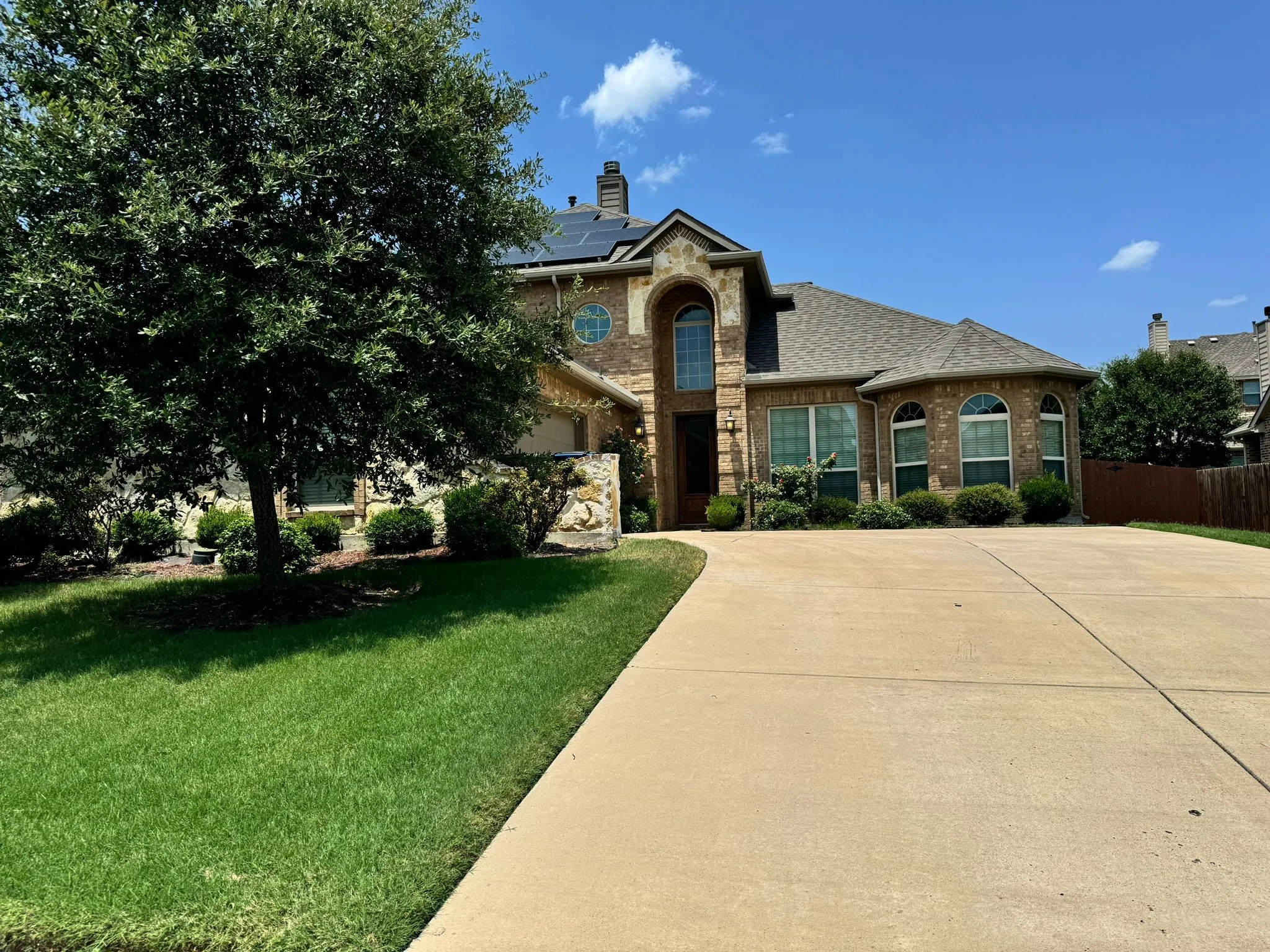 View of front of home with solar panels and a front lawn