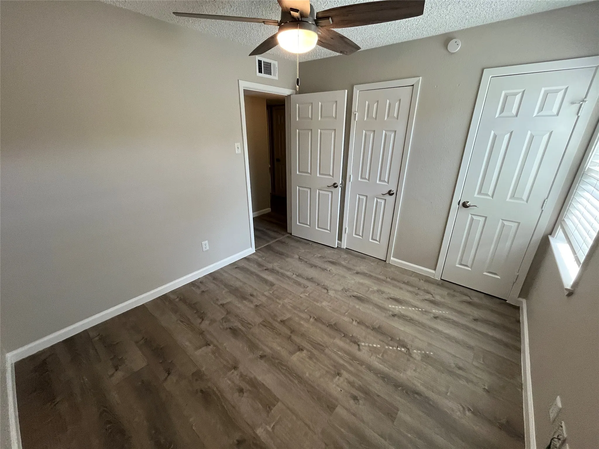 Wood-finish flooring, neutral wall tones, and white trim